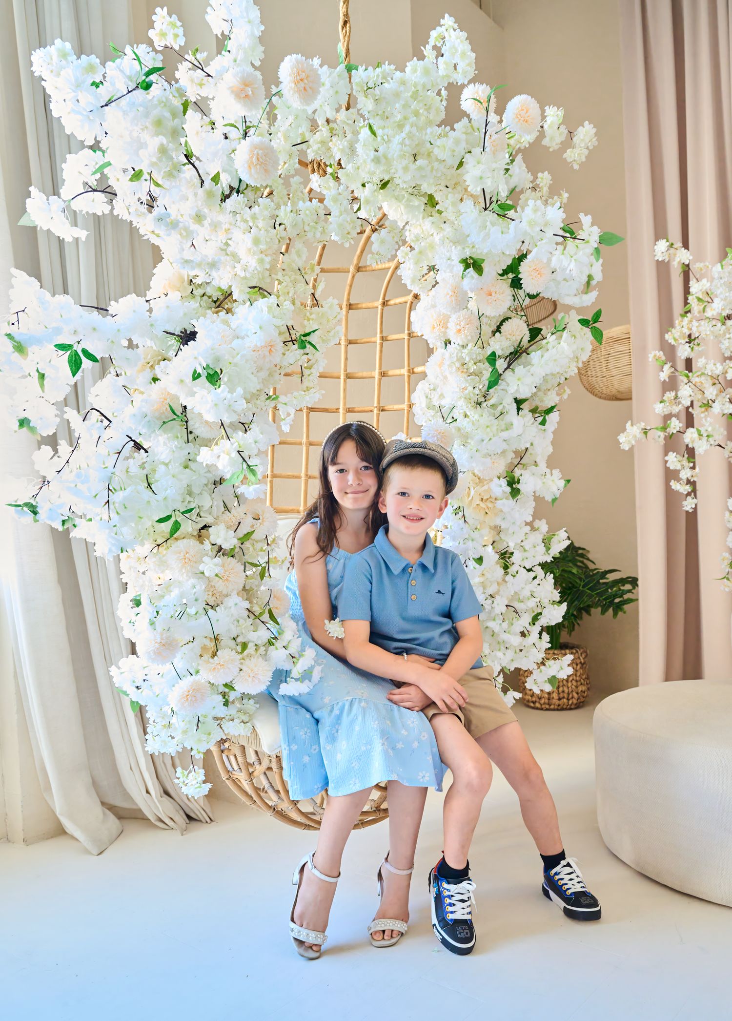 Brother and sister sitting together in a floral studio during a Toronto family photography session.