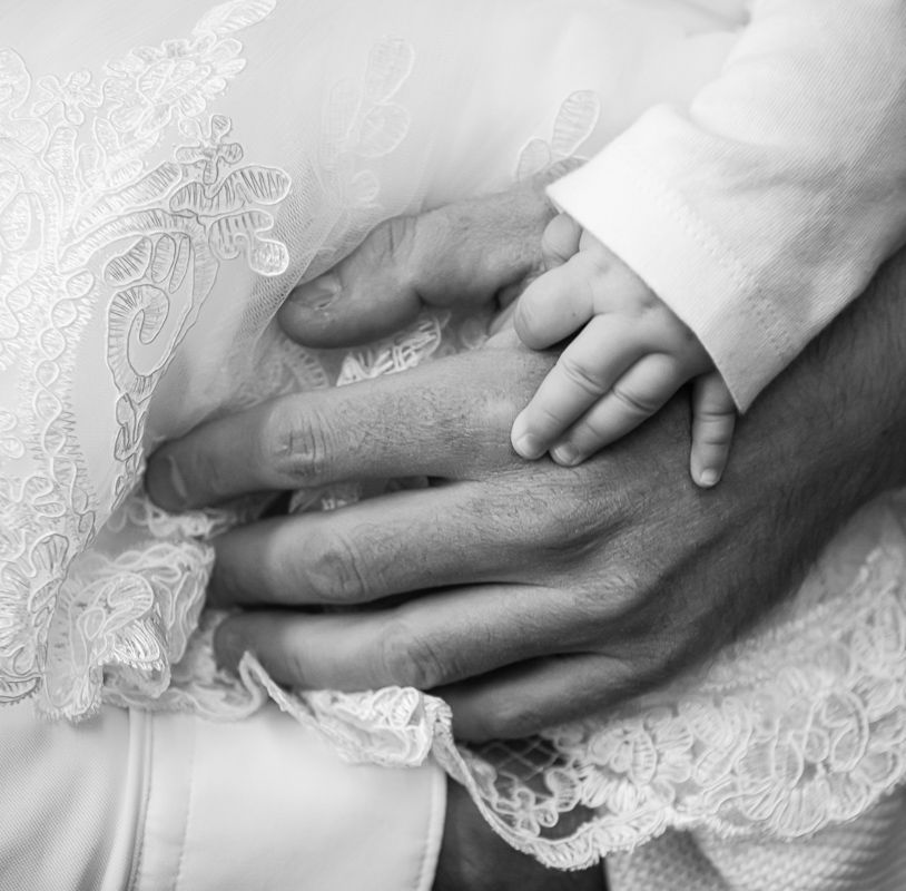 Close-up of a baby’s hand during a Toronto baptism photography session.