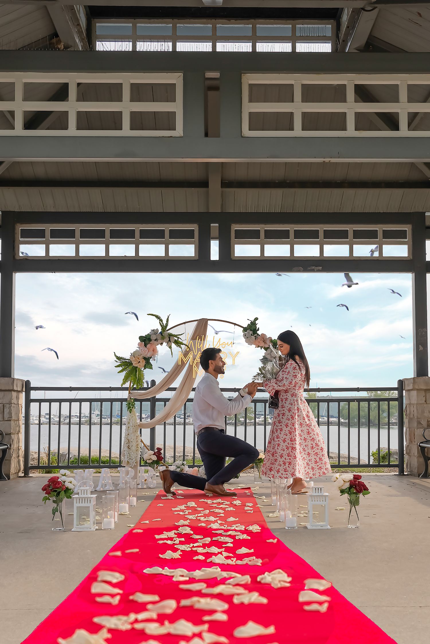Marriage proposal photographed at a Toronto waterfront pavilion with a decorated engagement setup.