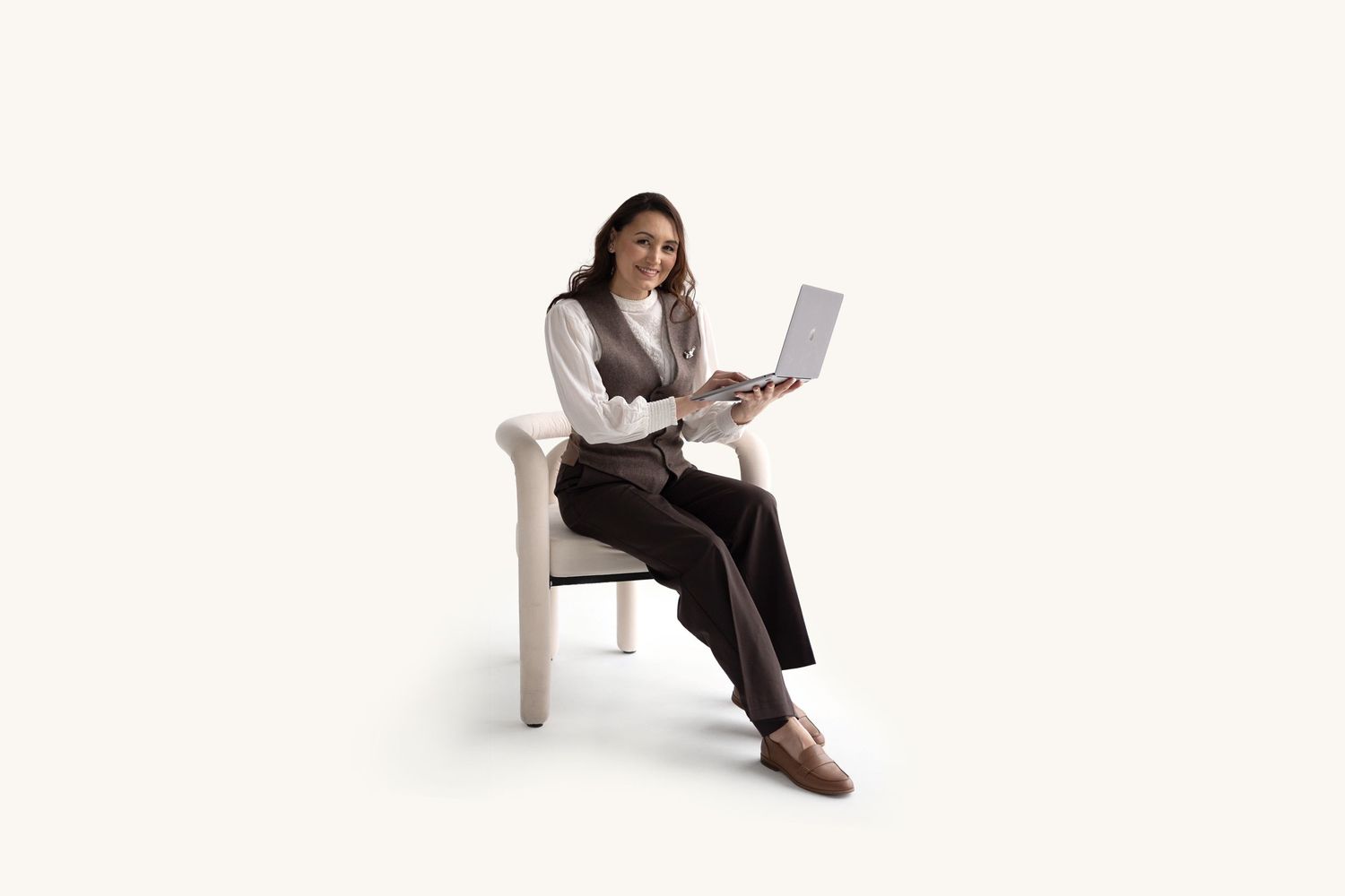 Viktoriia, founder of Victoria Vision Photography and Toronto family photographer, seated with a laptop in a bright studio.