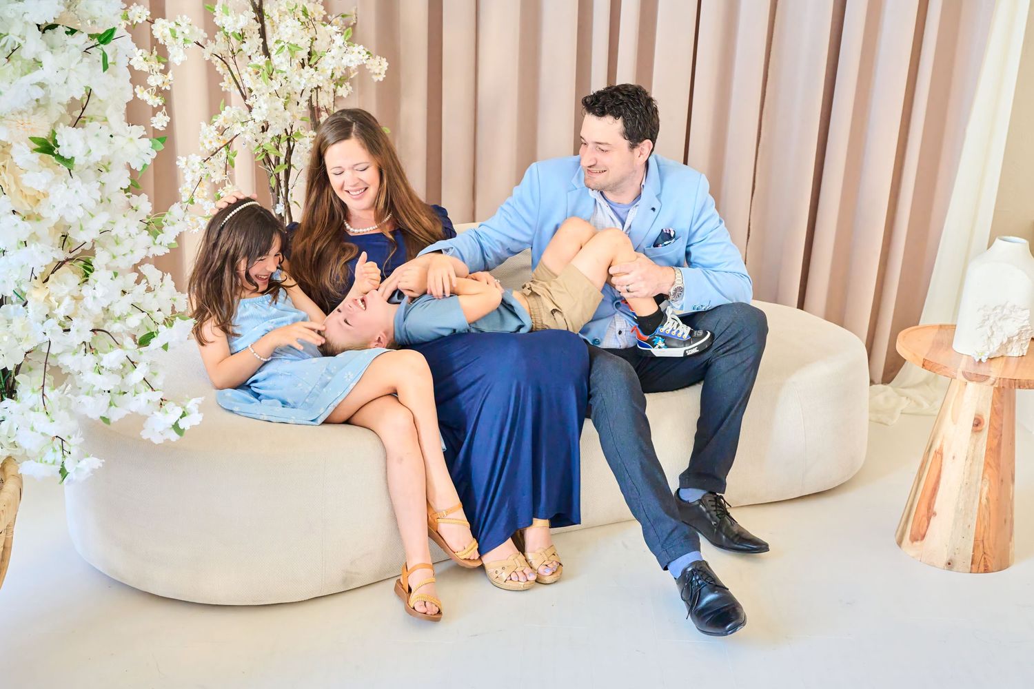 Family laughing together on a sofa during a relaxed Toronto studio family photography session.