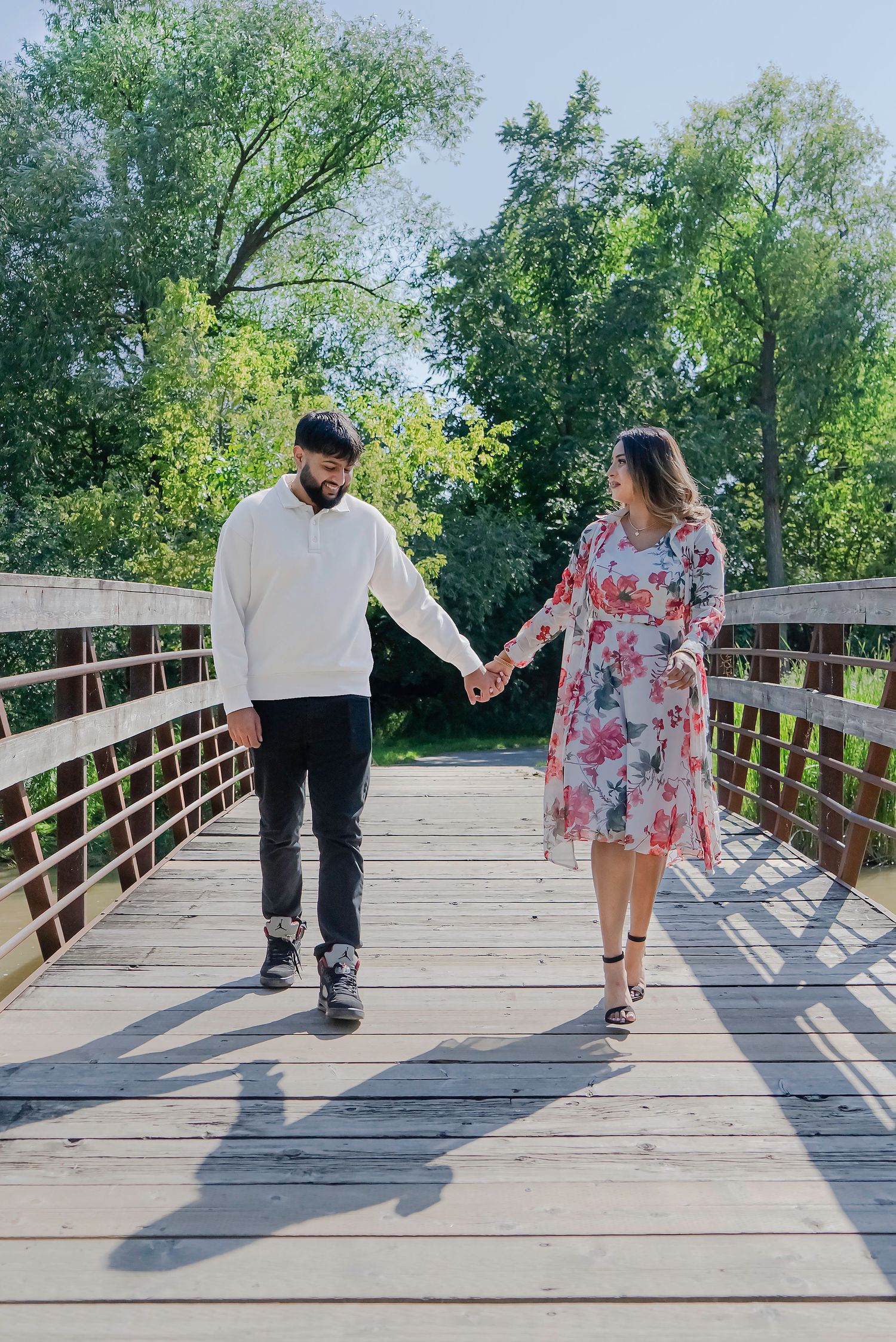Couple walking hand in hand during an outdoor Toronto engagement photography session.