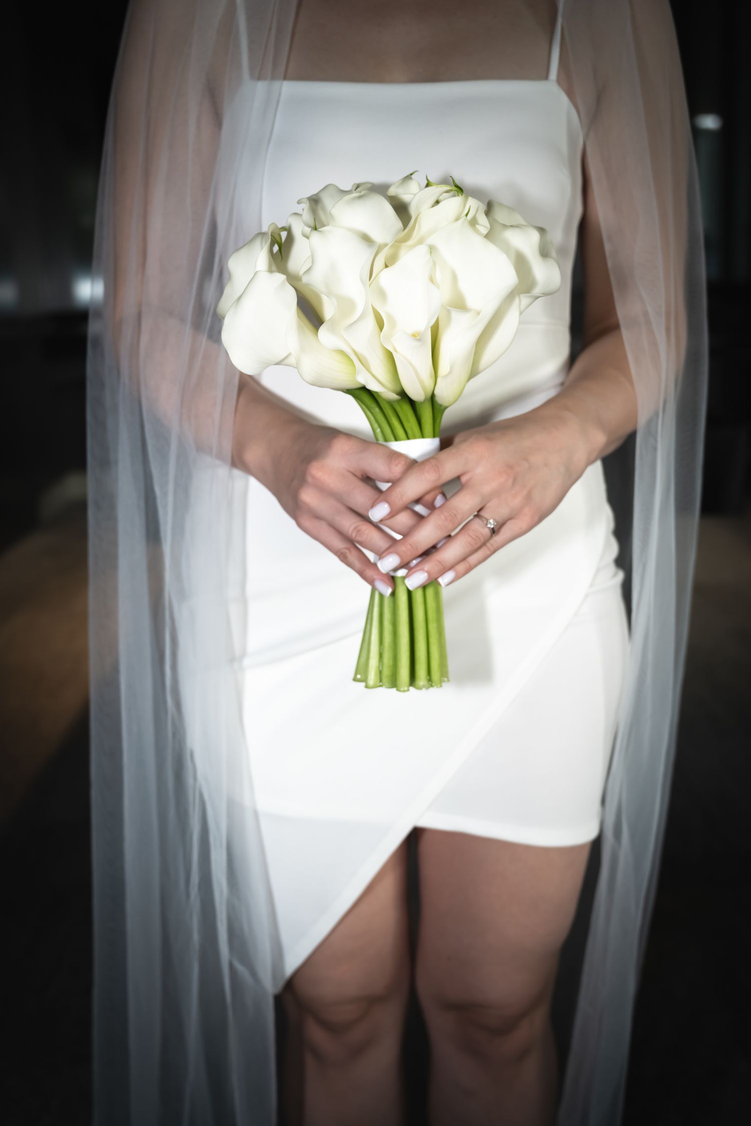 Bride holding a white calla lily bouquet before her Toronto wedding ceremony.