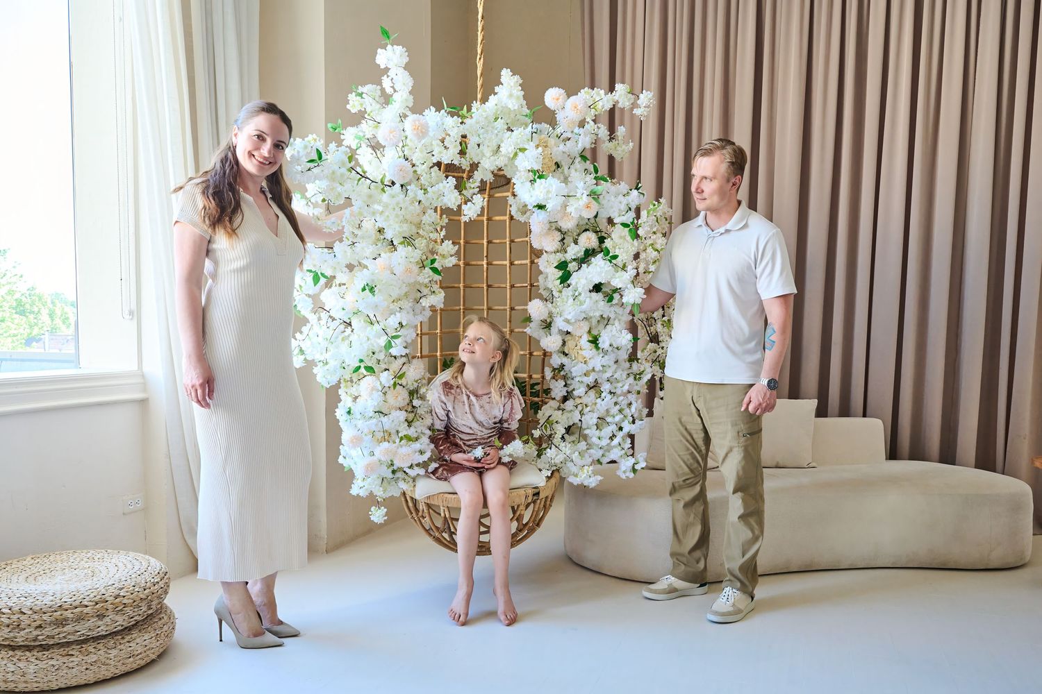 Parents posing with their daughter during a bright Toronto studio family photography session.