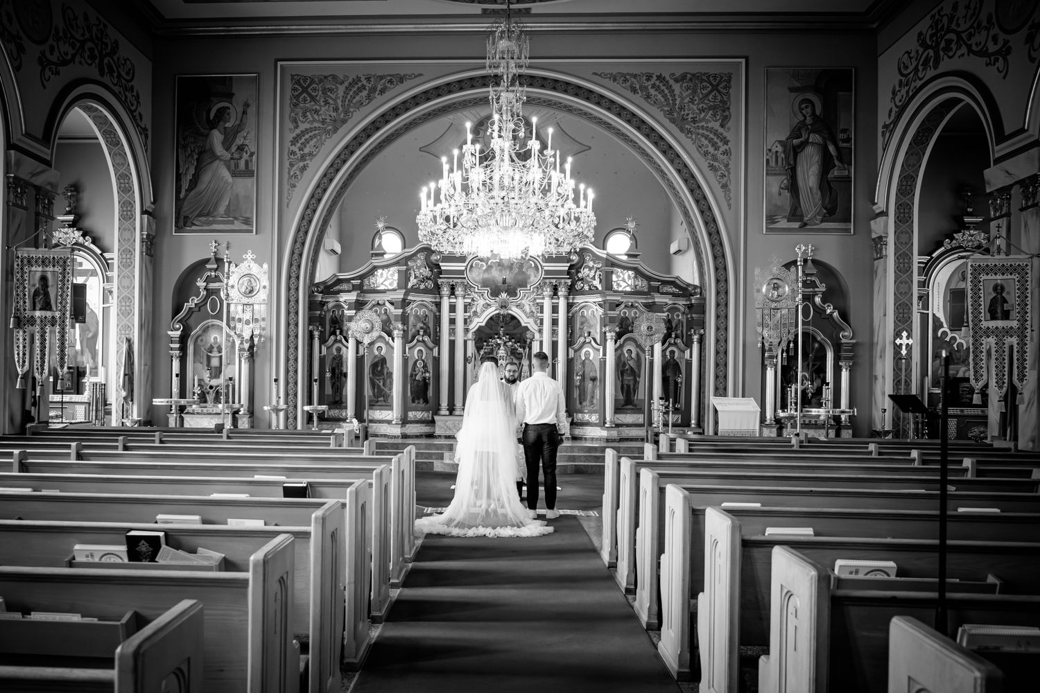 Black and white photograph of a bride and groom during a Toronto church wedding ceremony.