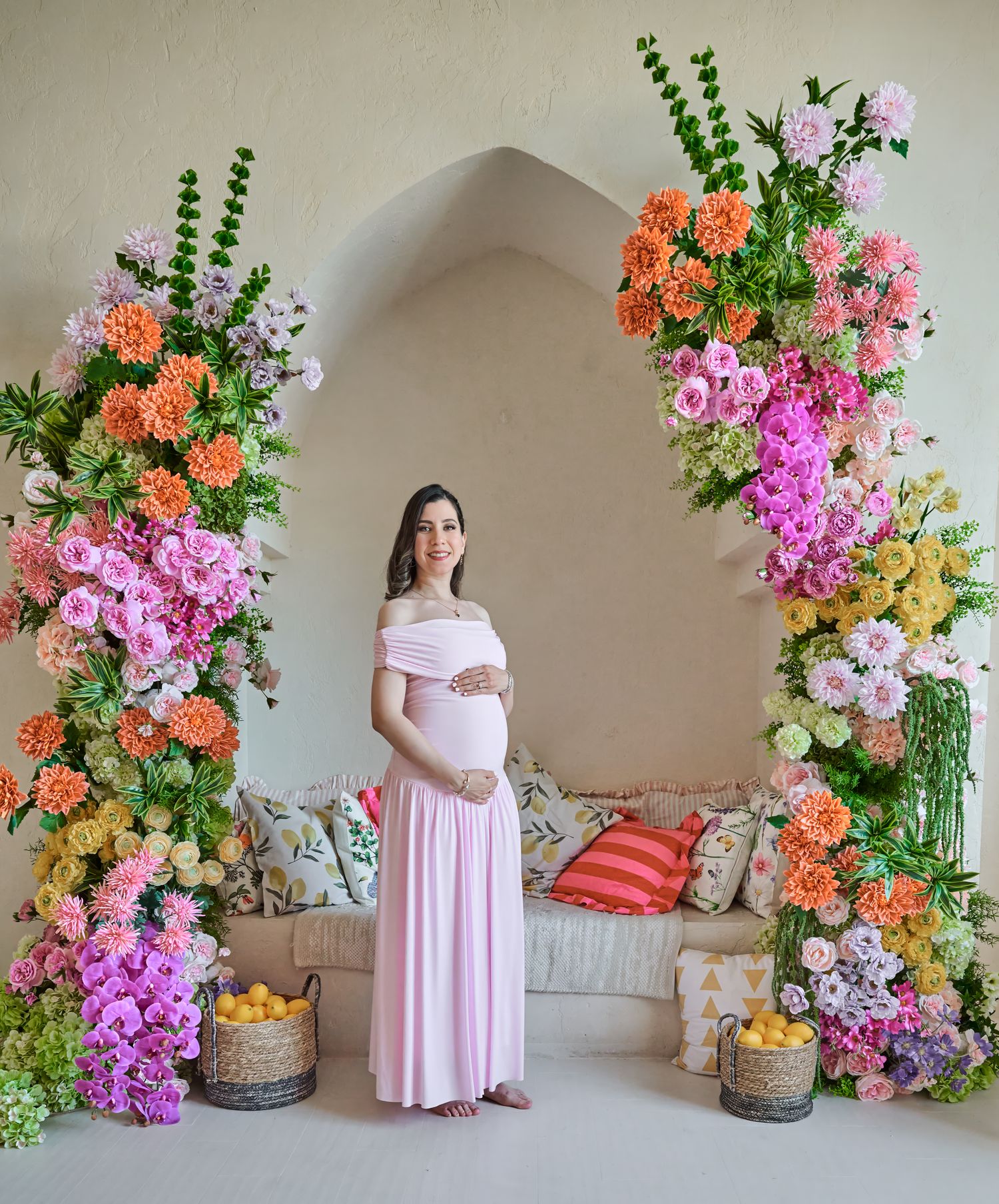 Pregnant woman posing in a pink dress during a Toronto studio maternity photography session.