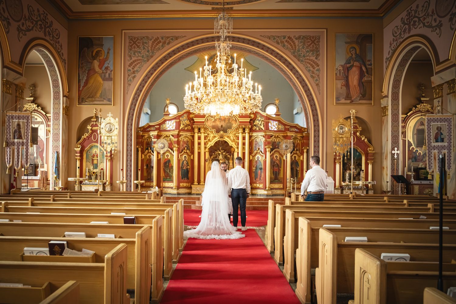 Bride and groom standing together inside an ornate Toronto church during their wedding ceremony.