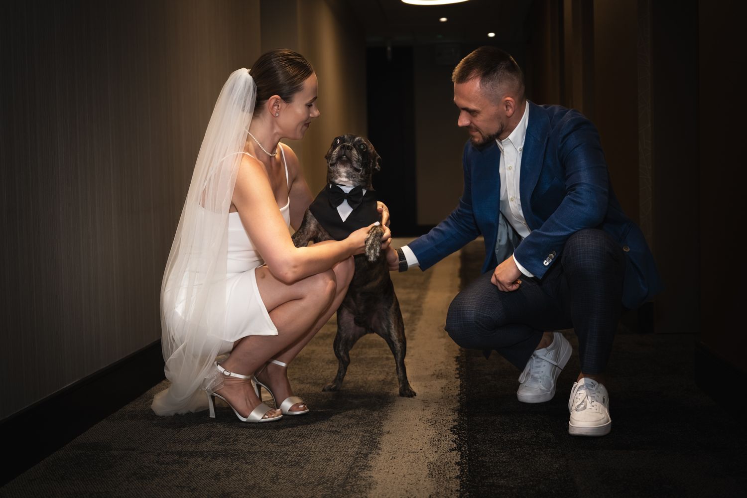 Bride and groom sharing a candid moment with their dog during a Toronto wedding celebration.