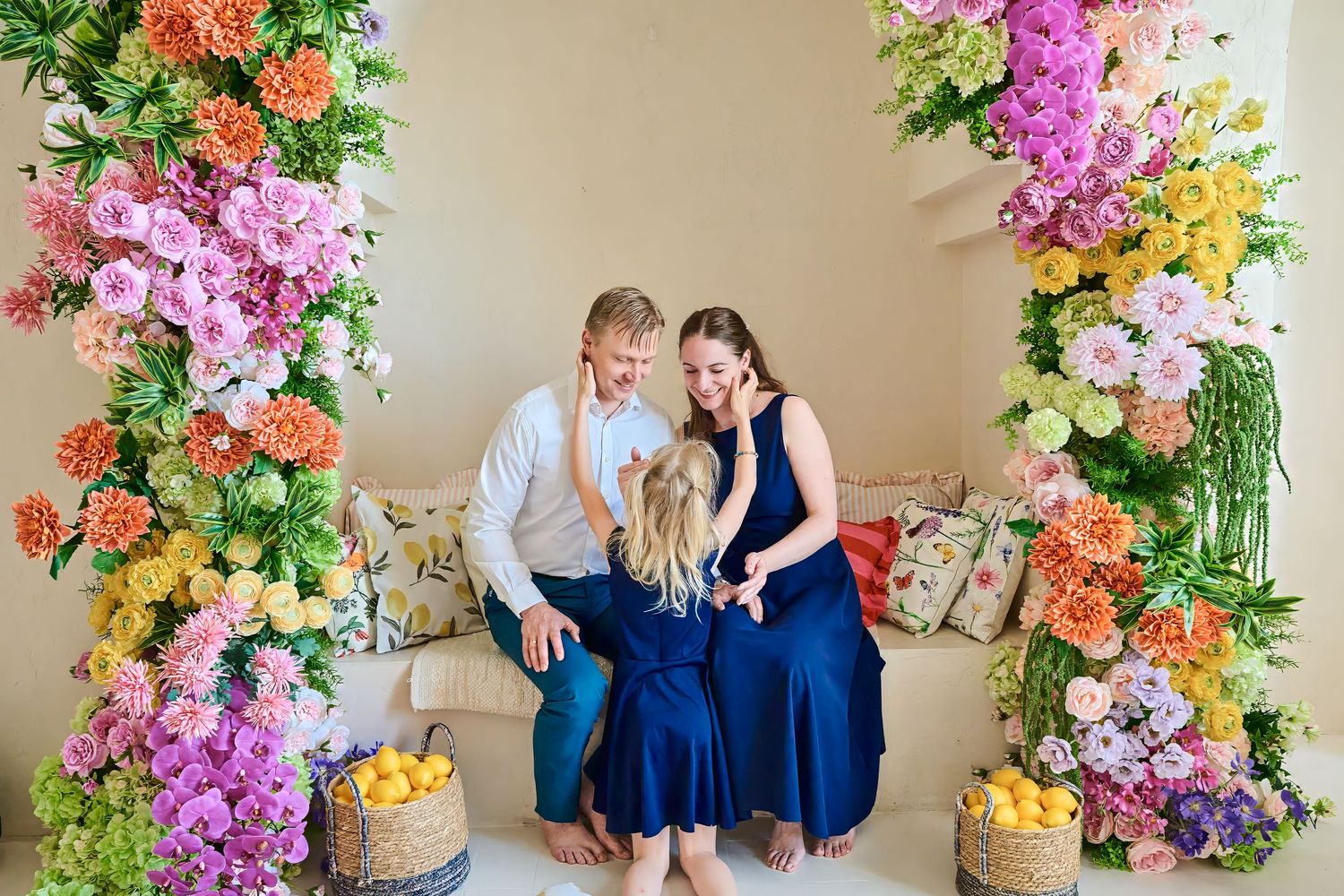Parents smiling with their daughter during a candid Toronto family photography session in a colourful studio.