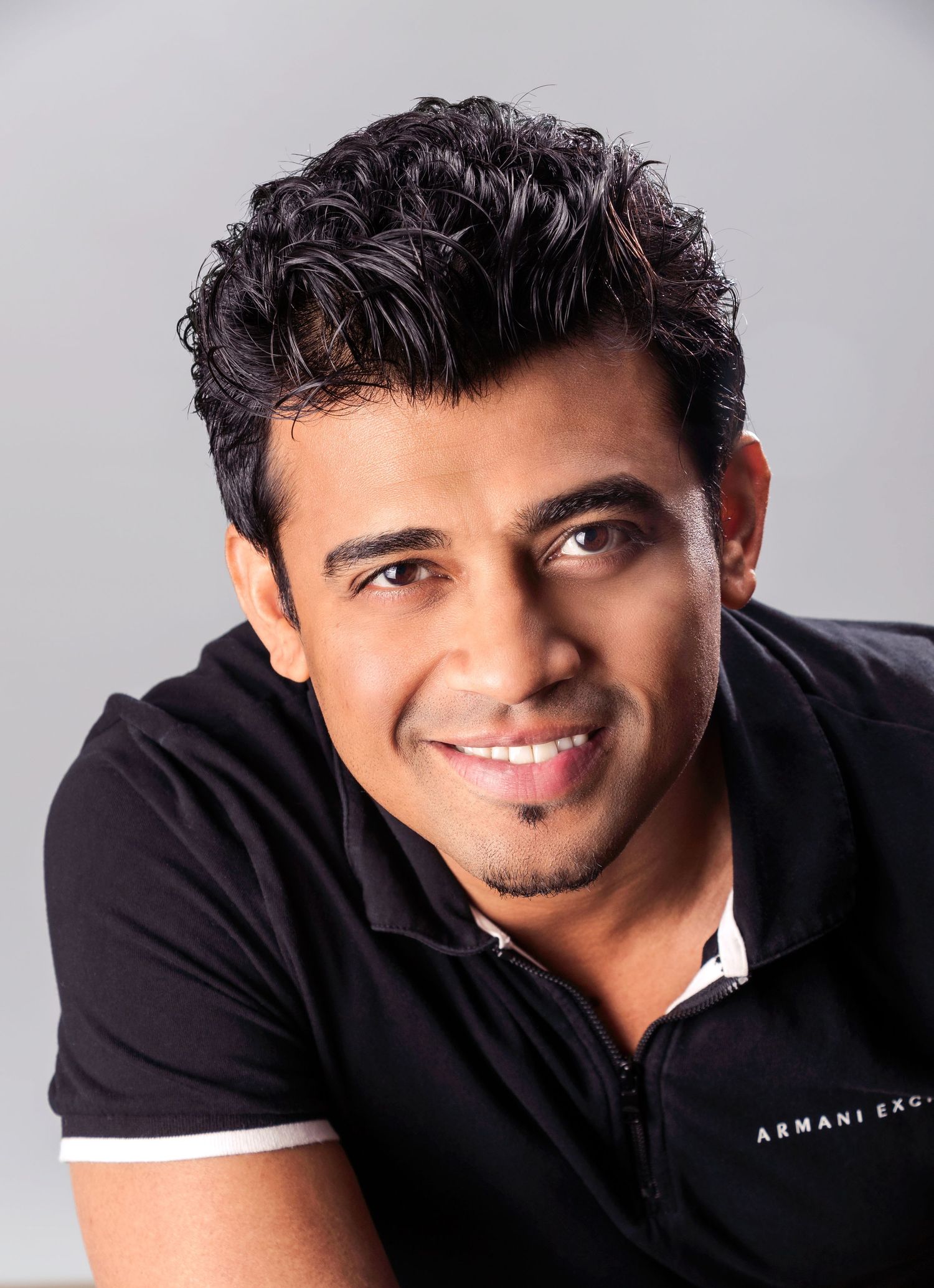 Studio portraits showing different expressions against light gray background.
