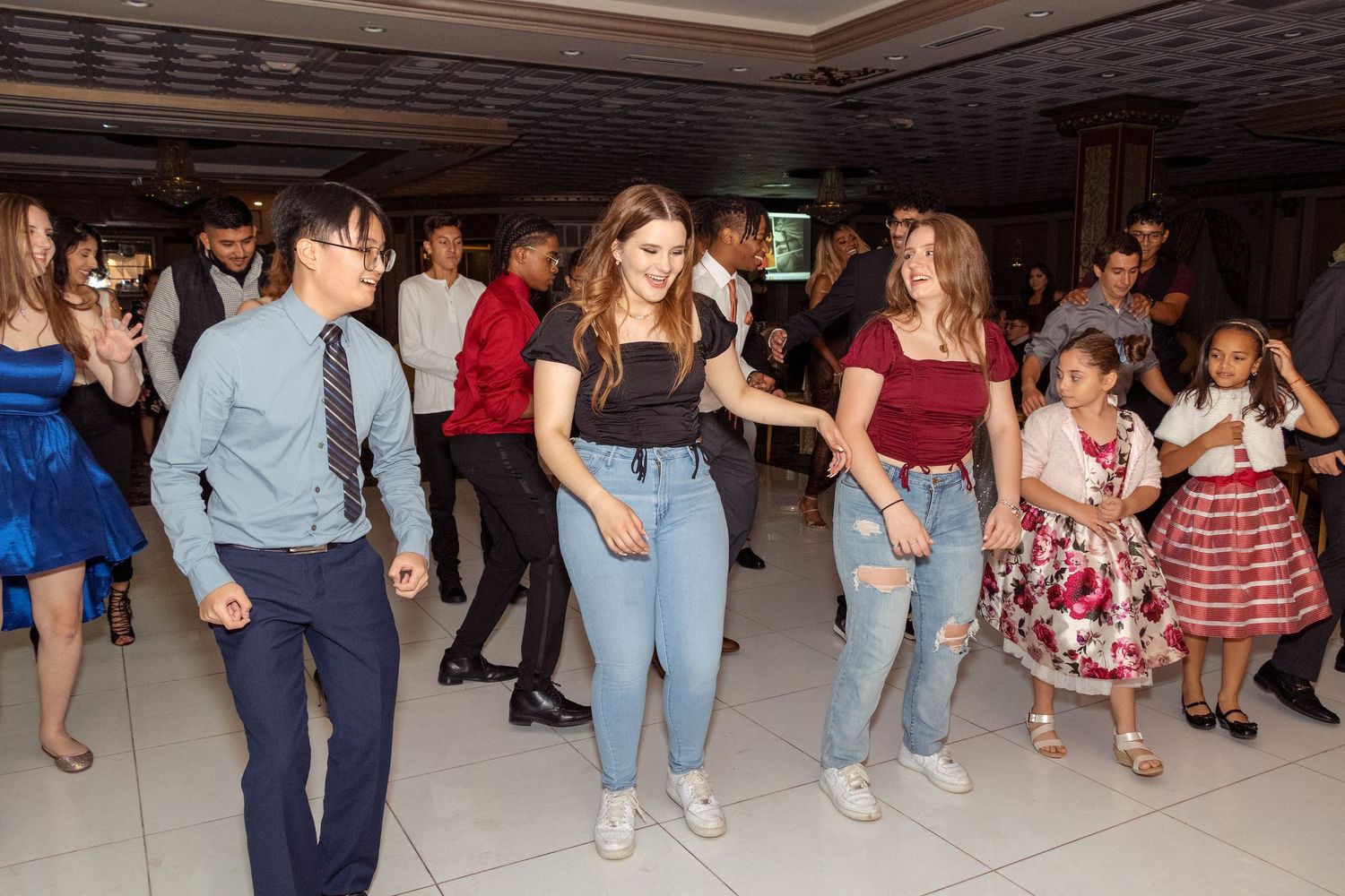 People dancing and mingling at a casual indoor social gathering.
