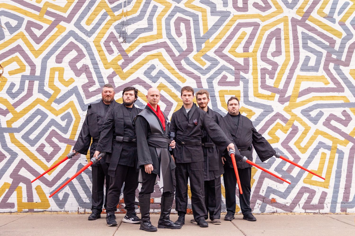 Wedding party group photo against colorful geometric wall mural.