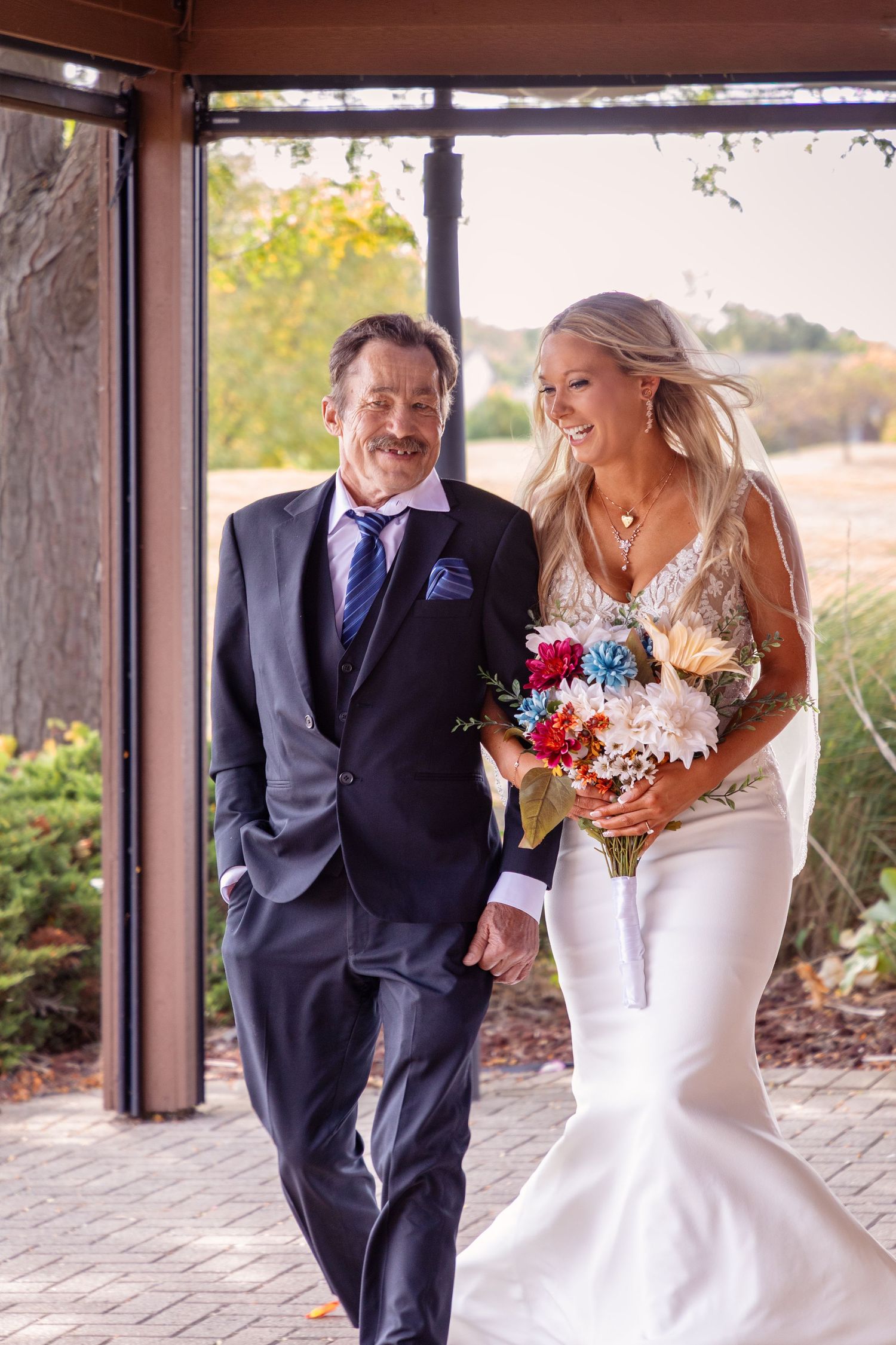 Bride and father share a candid moment before walking down the aisle.