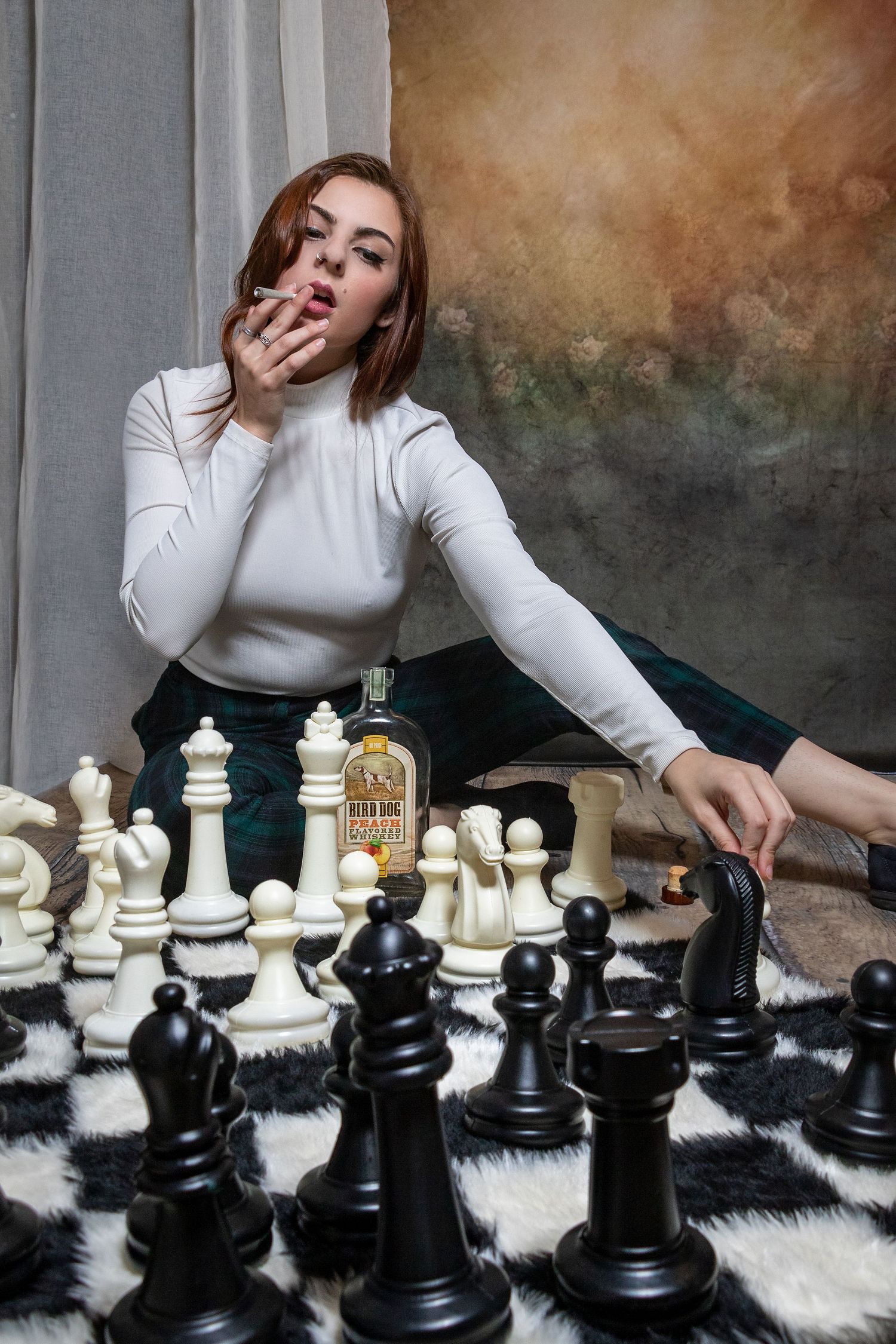 Artistic chess-themed portrait series with oversized pieces on furry white surface.