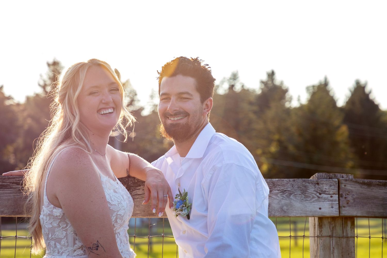 A couple shares a romantic moment in a sunlit outdoor setting during their wedding photoshoot.