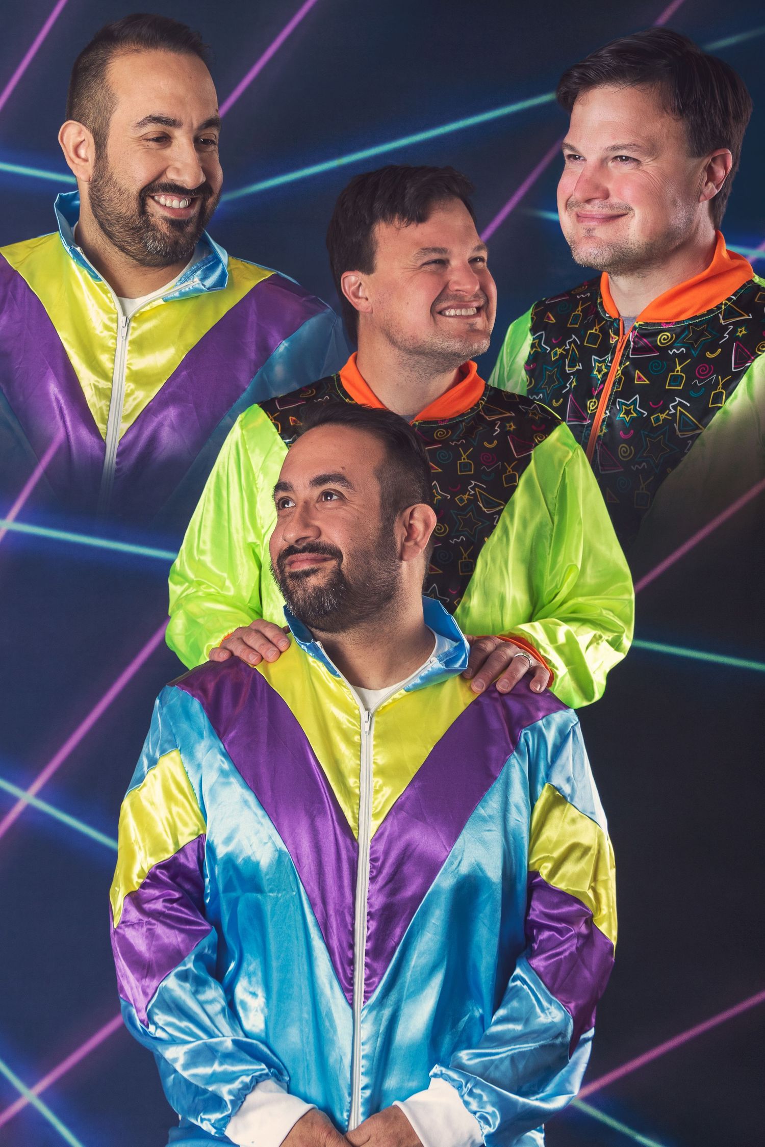 People wearing colorful 90s style windbreakers pose against neon geometric backdrop.