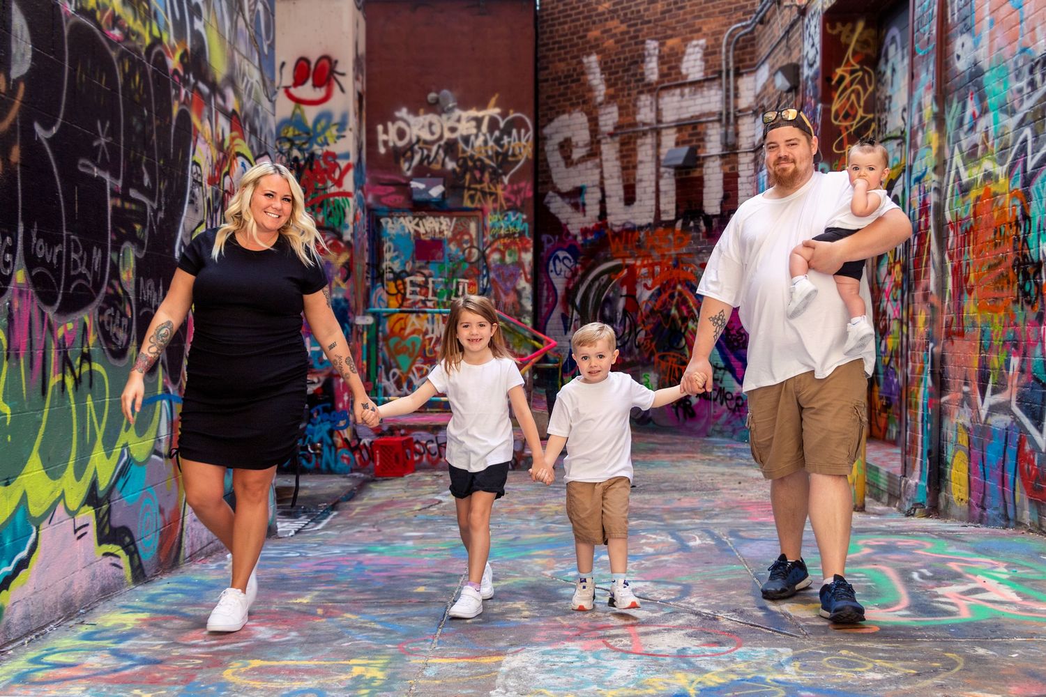 Urban family photos against colorful graffiti wall art.