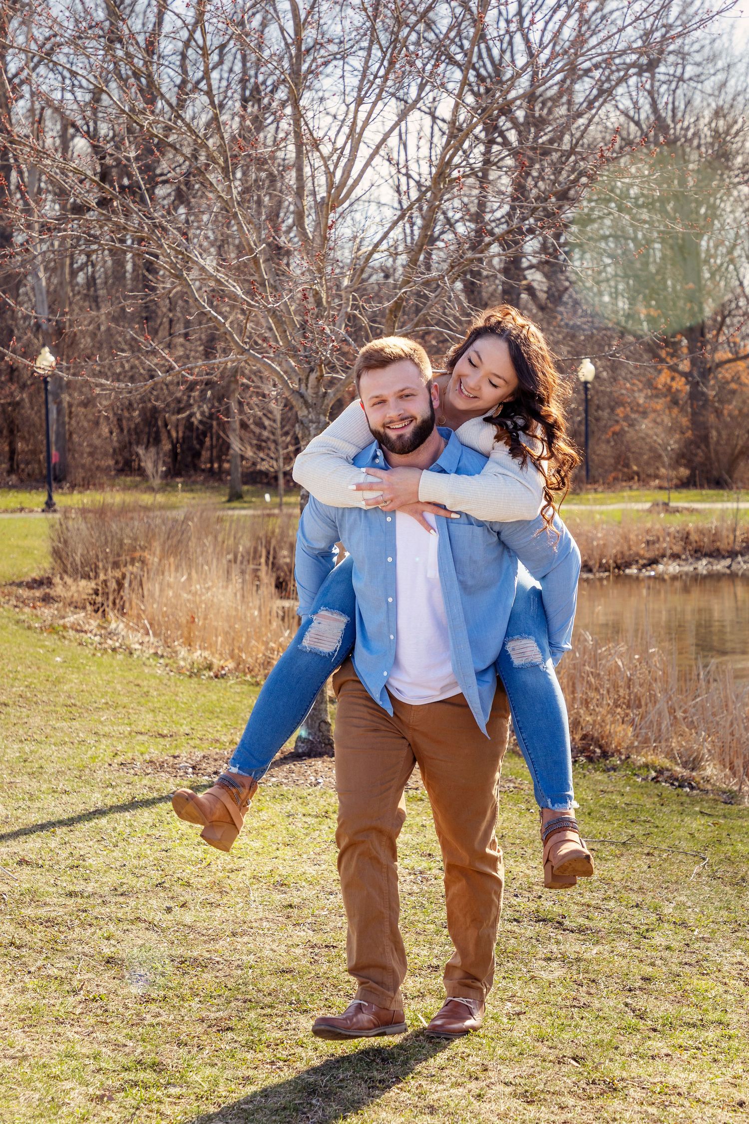 A playful piggyback ride moment captured in a park setting during early spring.