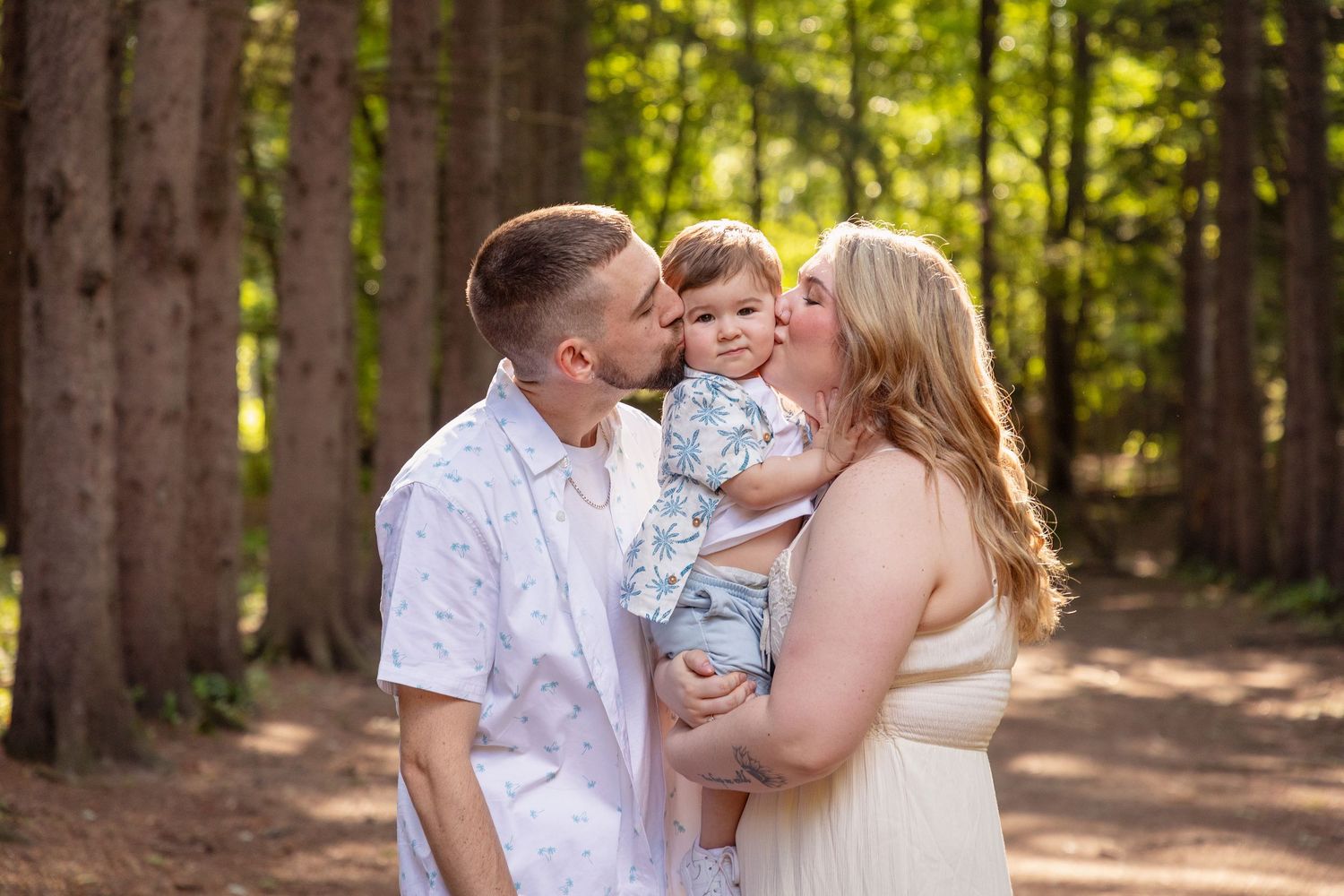A family sharing tender moments together in a sunlit forest setting.