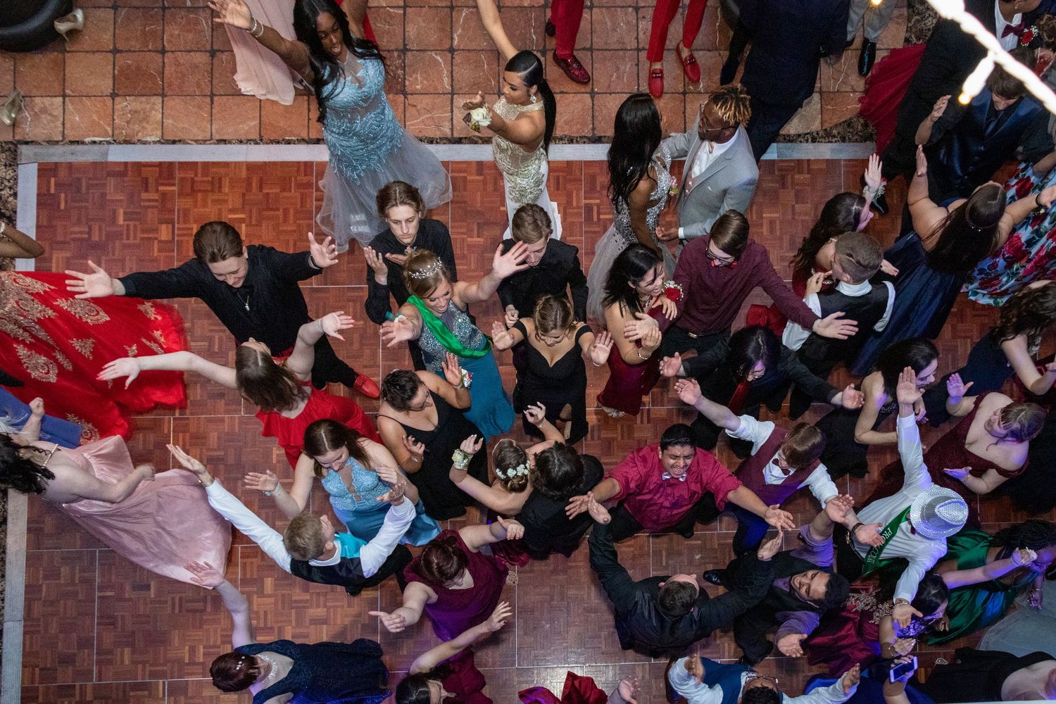 Large group of wedding guests pose together on brick steps for a fun photo.