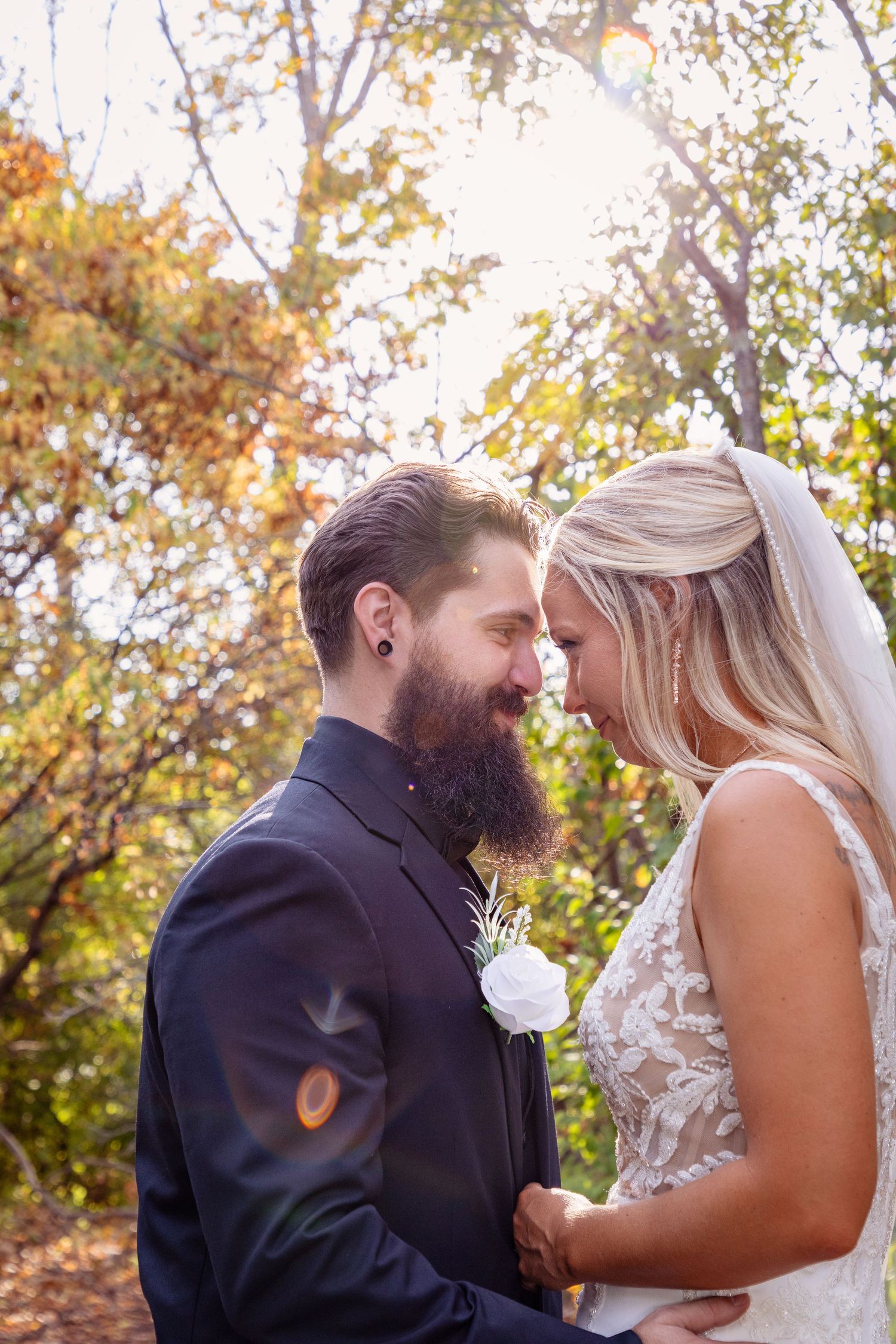 A romantic moment between newlyweds surrounded by autumn foliage.
