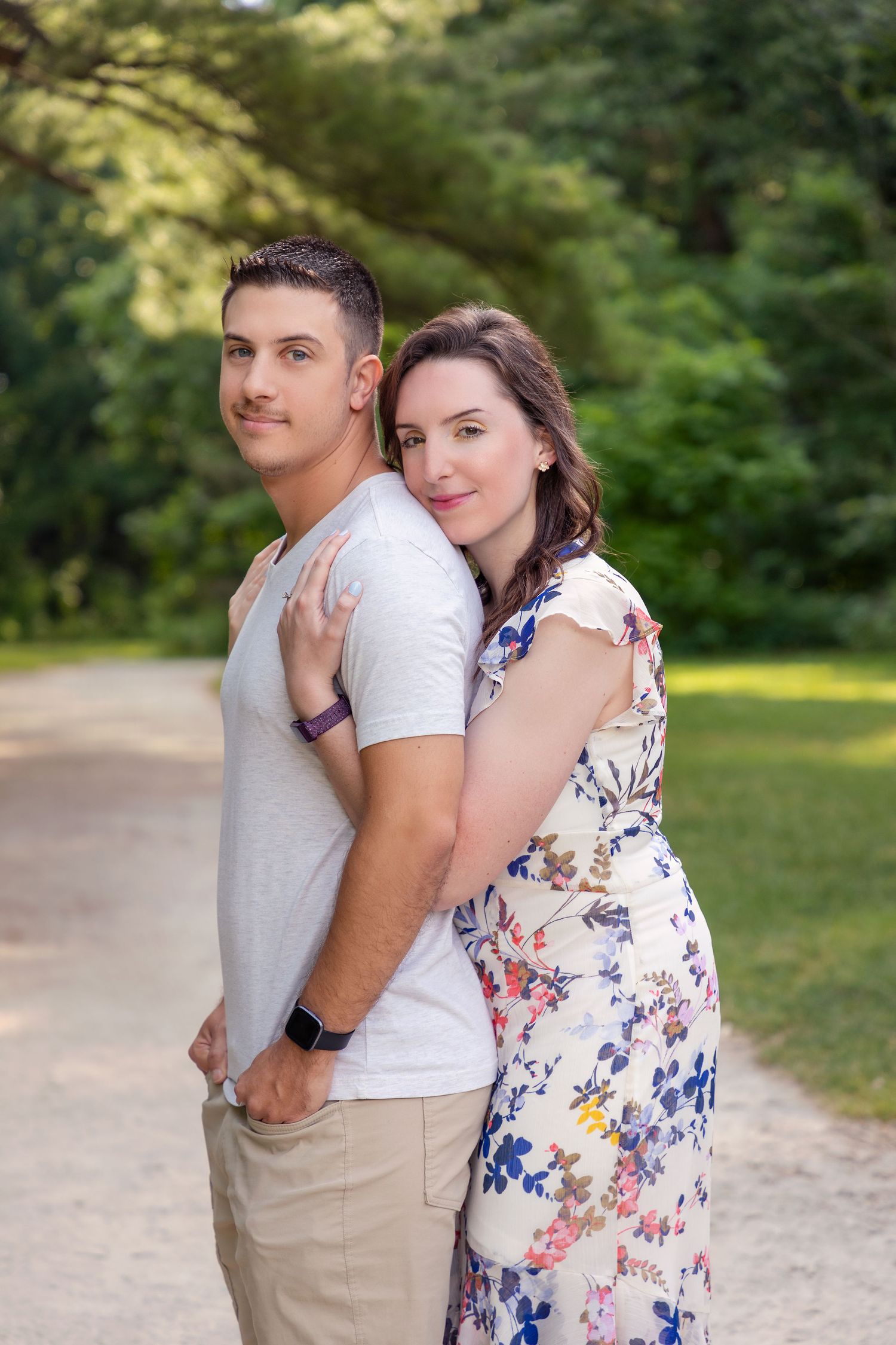 A couple poses together on a garden path surrounded by greenery.