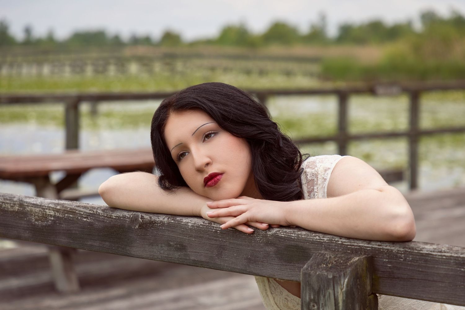 Dreamy portrait series on wooden boardwalk with rustic railing.