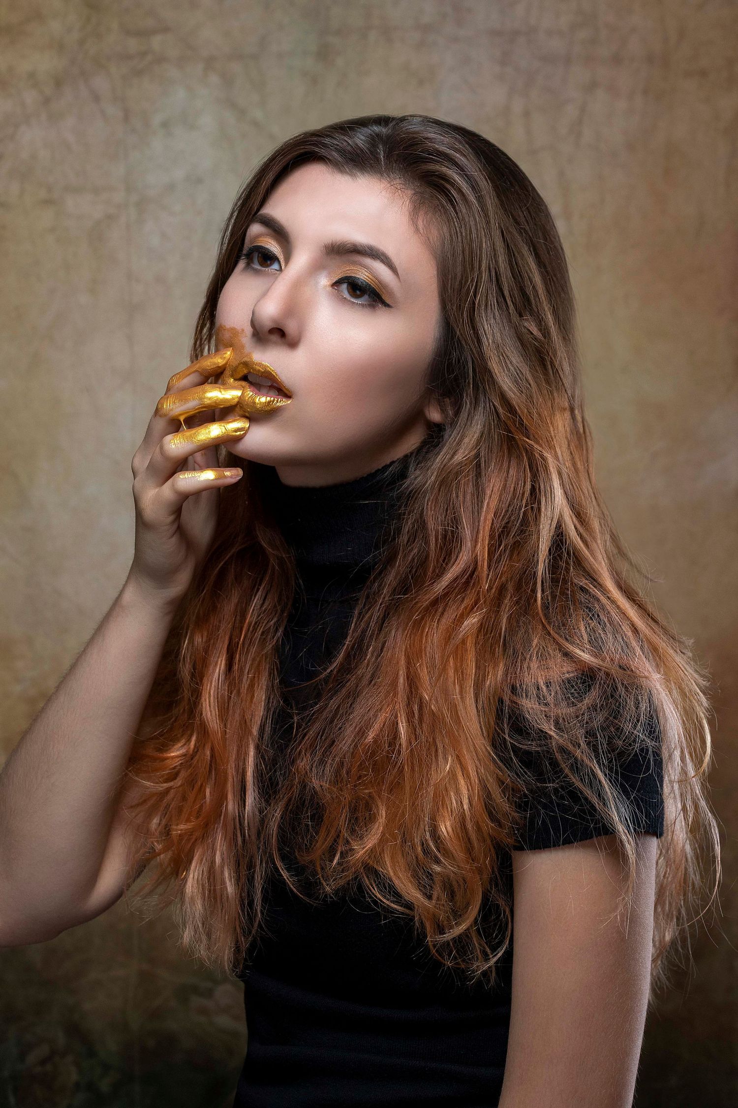 Artistic portrait series featuring gold-painted hands and dramatic makeup in moody lighting.