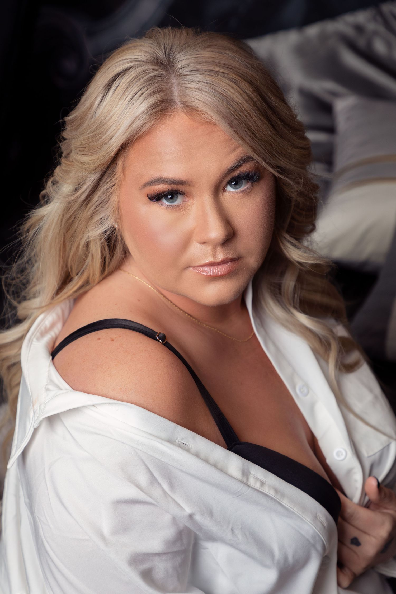 Elegant studio portraits with soft lighting and white button-down shirt.