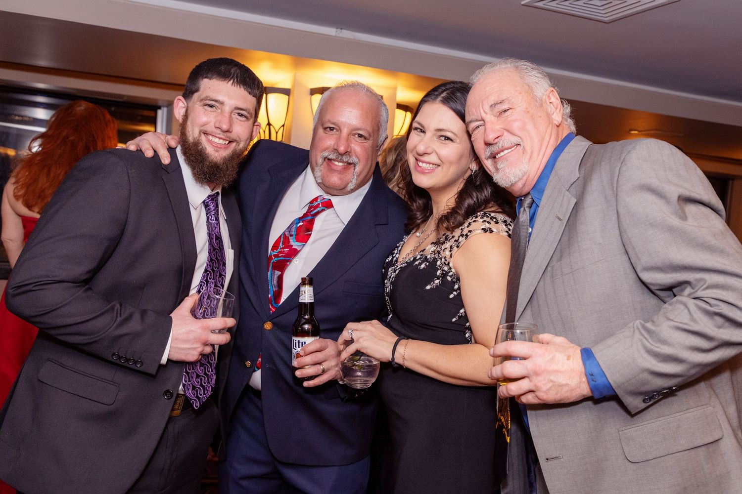 Group of people in formal attire smiling and celebrating together at an event.