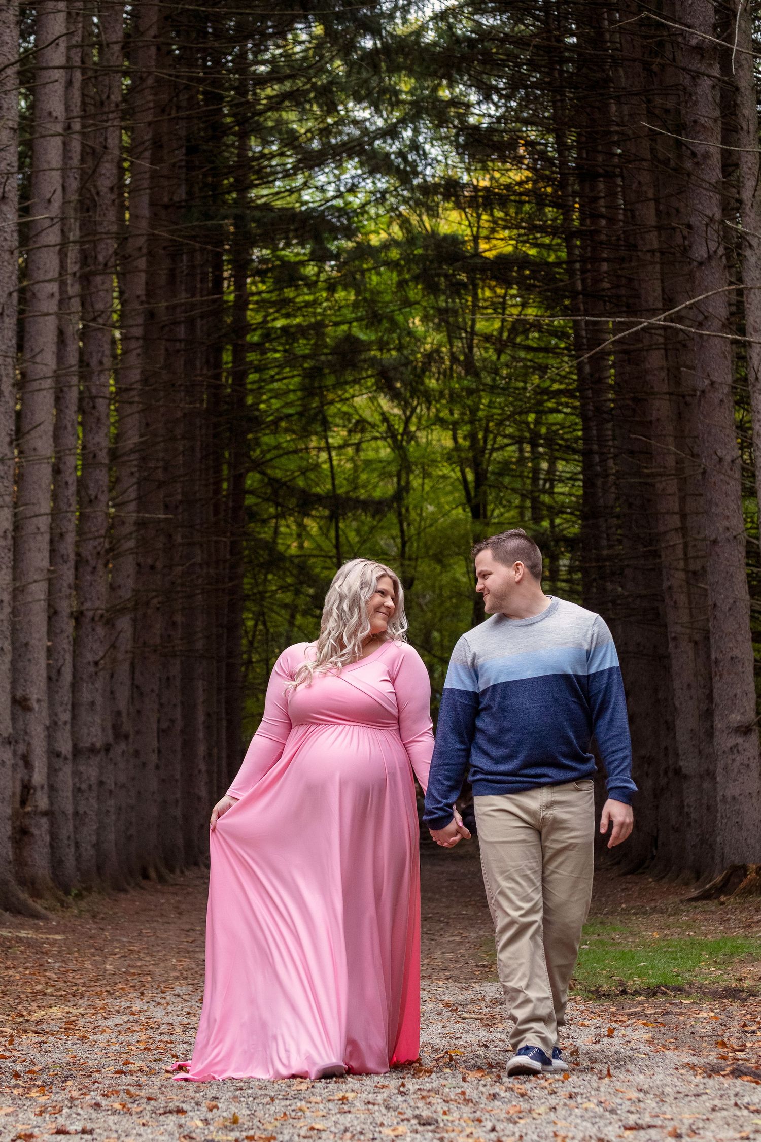 Romantic couple photos in a pine forest with fallen leaves.