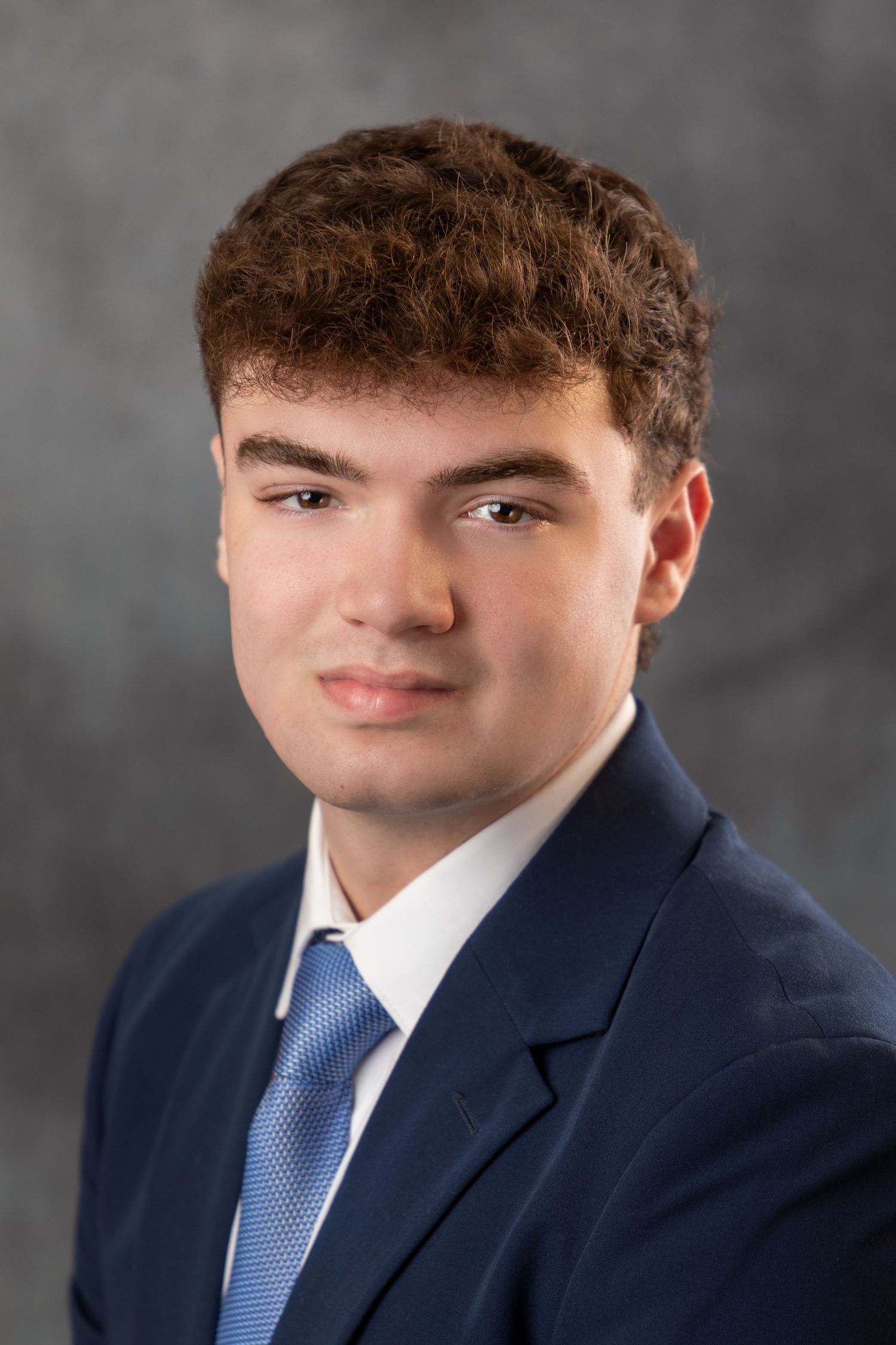 Professional headshot sequence of someone in navy suit and blue tie against dark background.