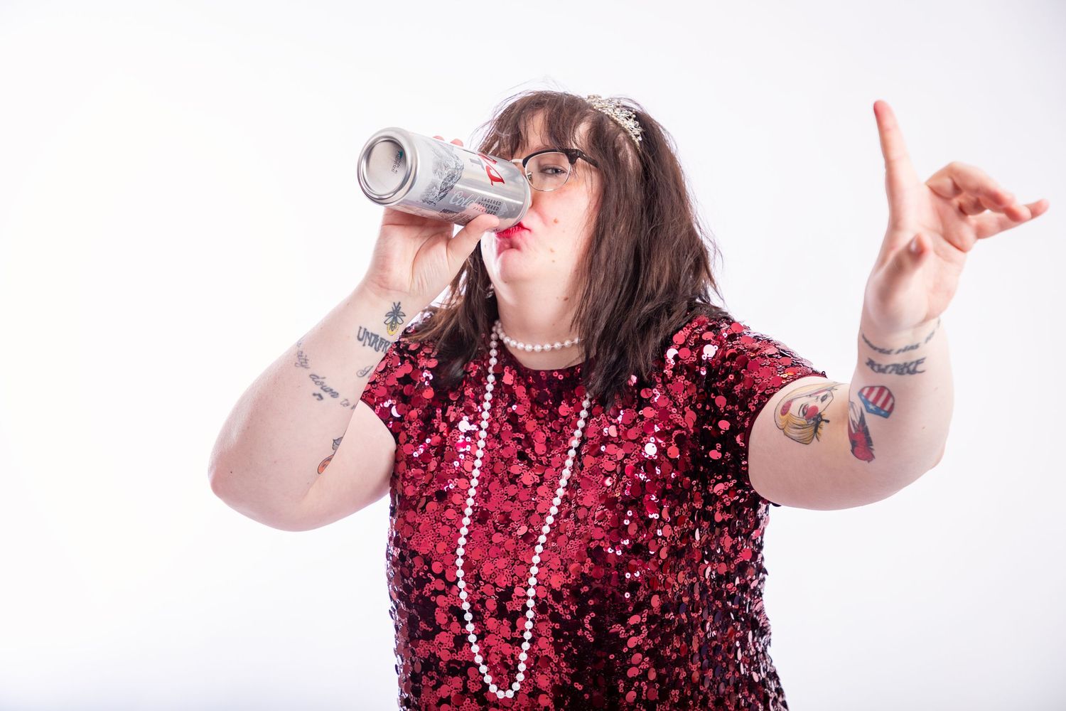 Woman in sparkly red dress poses playfully with a fun party attitude.