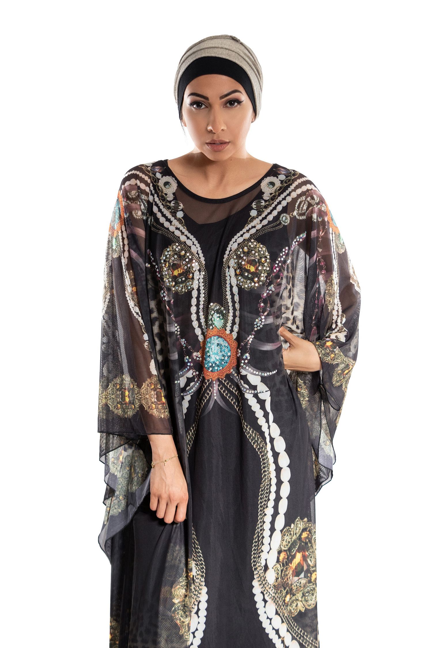 Elegant model wearing an ornate black sheer kaftan with embellished details and a turban-style headpiece.