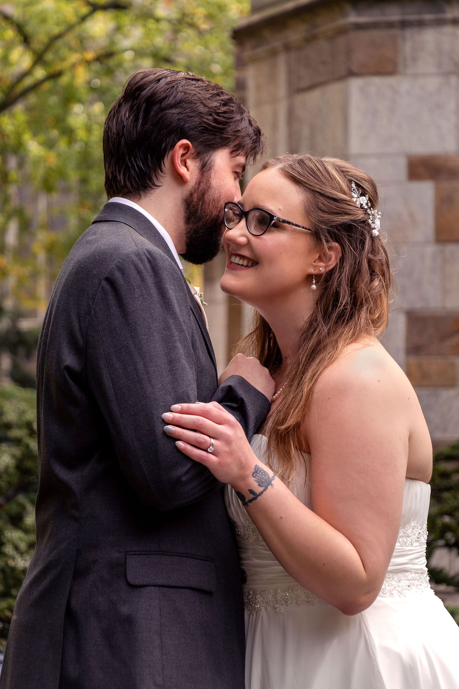 A tender moment between newlyweds sharing laughter during their outdoor wedding portraits.