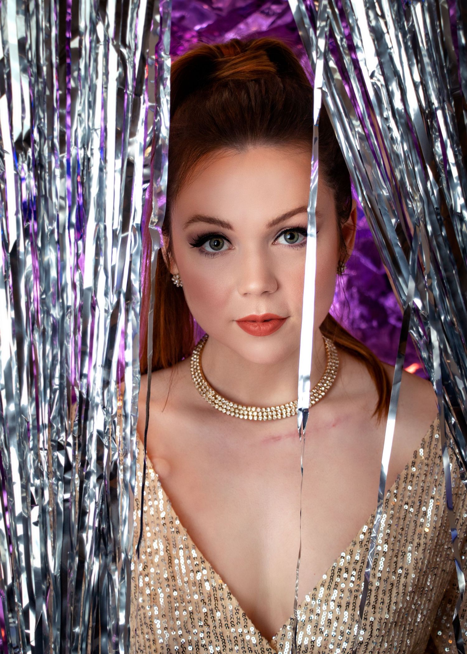 Glamorous portrait series with sparkly gold dress and metallic tinsel backdrop.