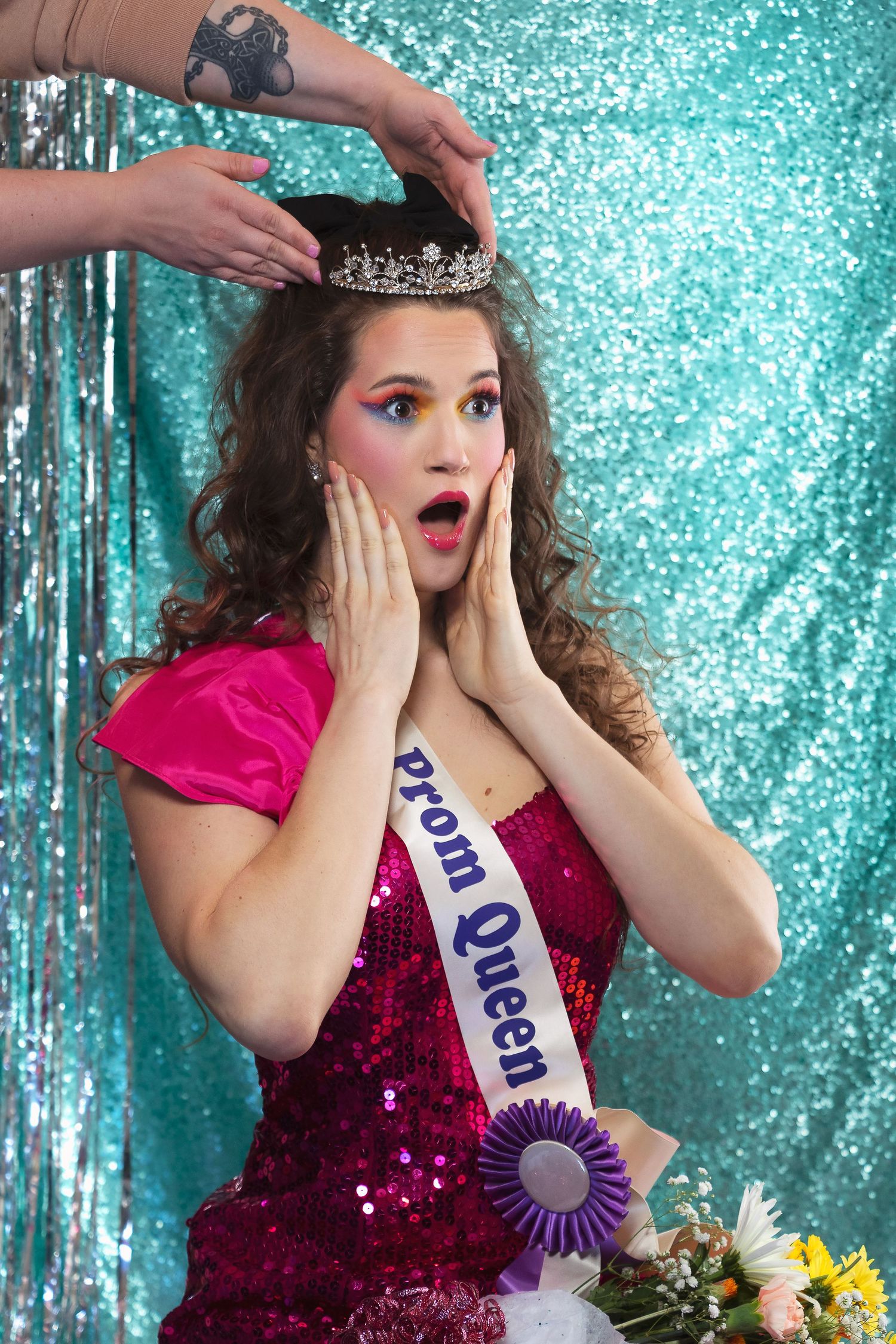 Pageant-style portraits with crown and sash showing surprised expressions against sparkly turquoise backdrop.