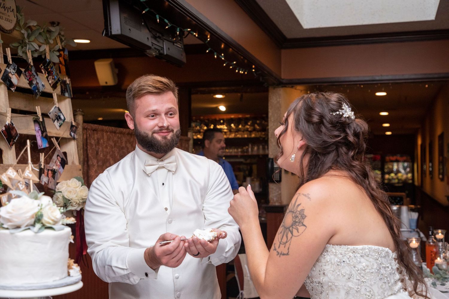 Wedding reception celebration inside rustic venue with warm lighting and decorations.