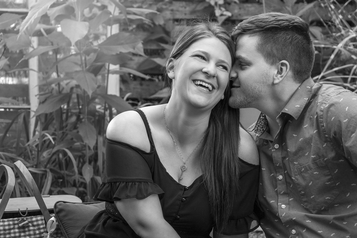 A black and white candid moment captured in a garden setting.