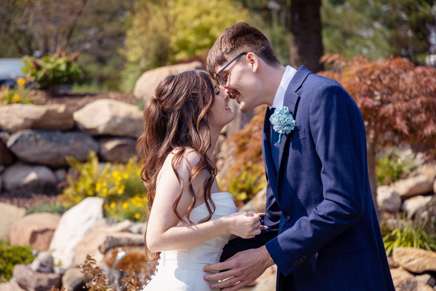 Romantic outdoor wedding portraits captured in garden setting with natural fall colors.
