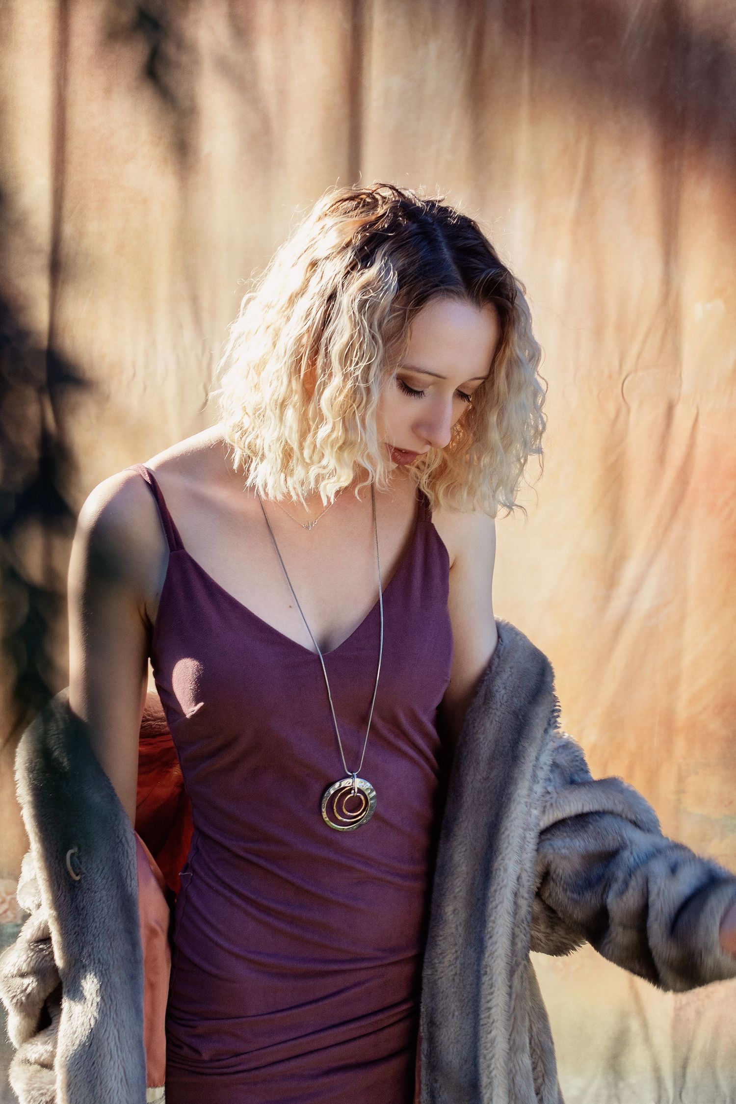Portrait series showing person in purple top and gray cardigan against warm natural lighting.