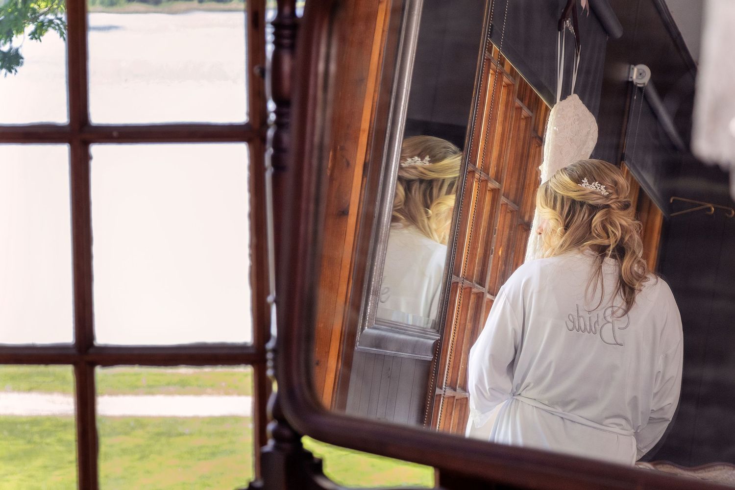 Wedding preparation moments captured through window panes with natural lighting.