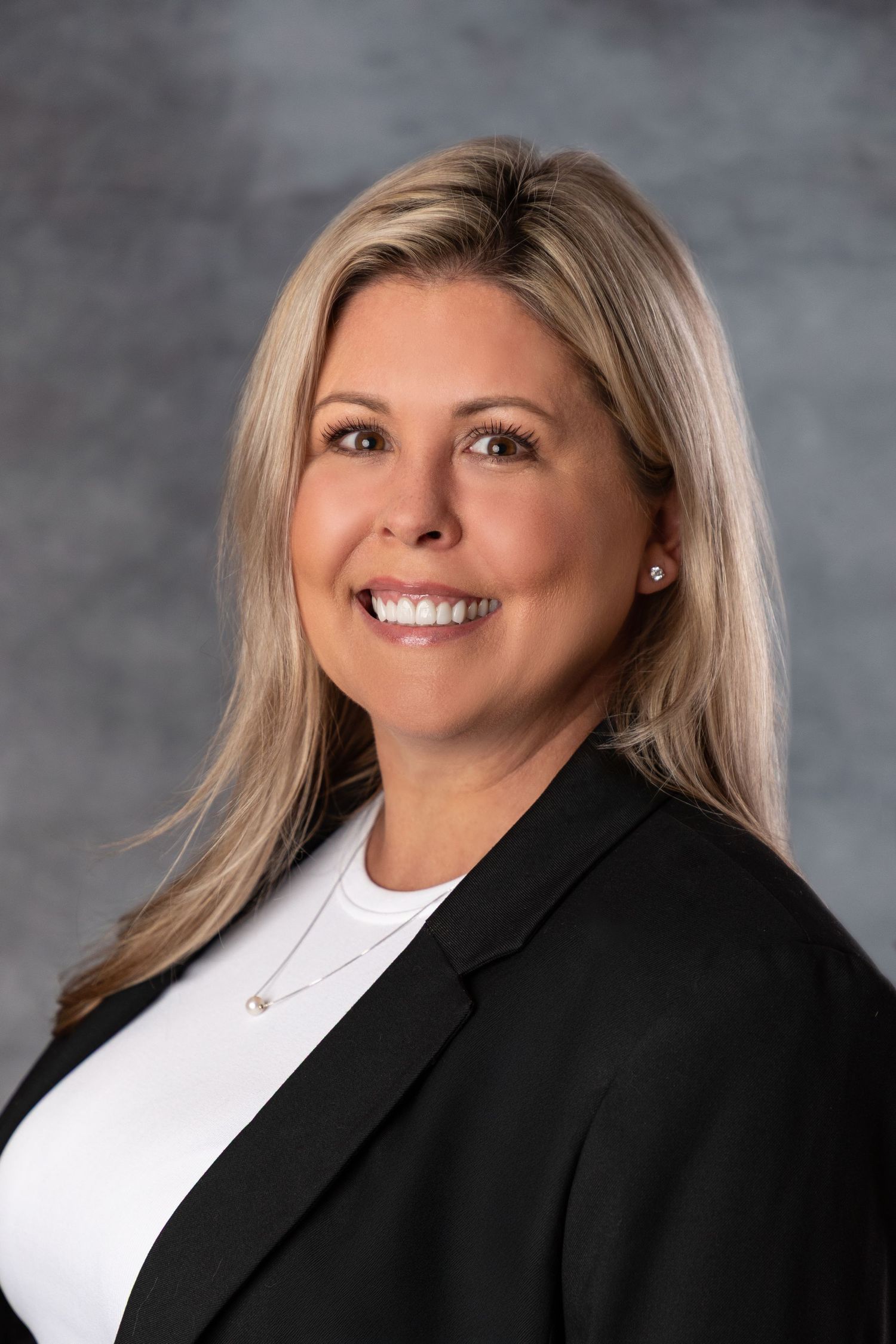 Professional headshot series showing someone in black blazer and white top against gray background.