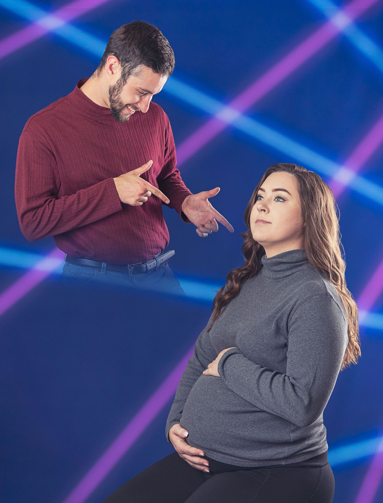 A maternity photoshoot against a blue background with dramatic lighting effects.
