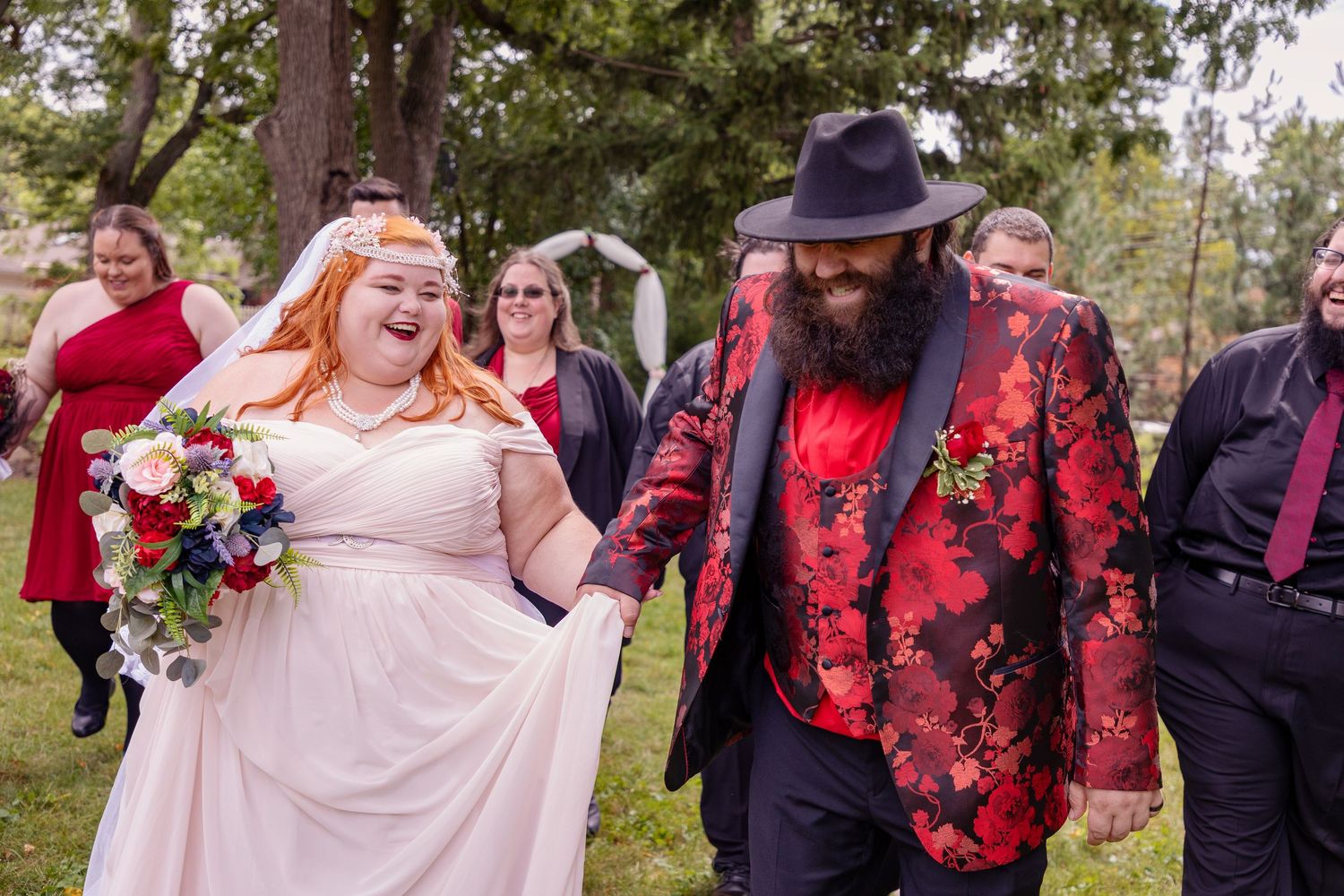 Wedding celebration in a garden setting with guests and floral decorations.