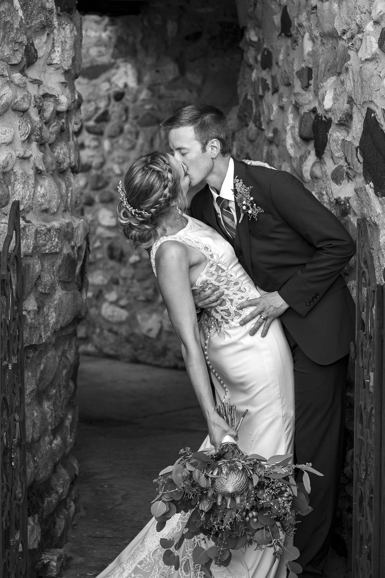 Black and white wedding portraits taken in a stone archway.