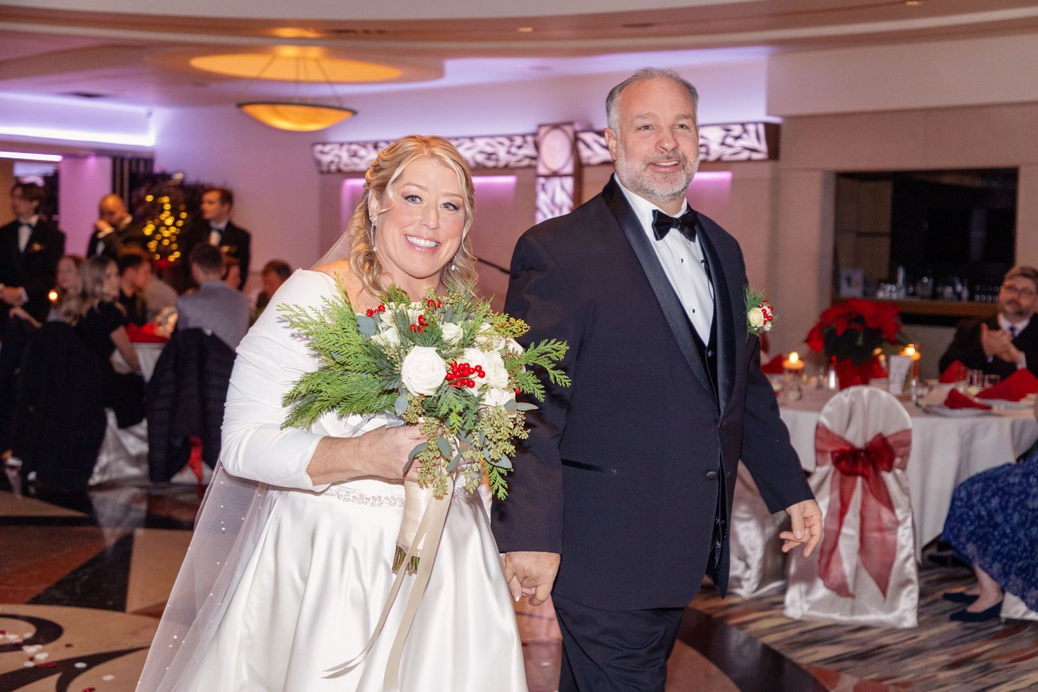 Wedding reception hall with elegant table settings and holiday decorations.