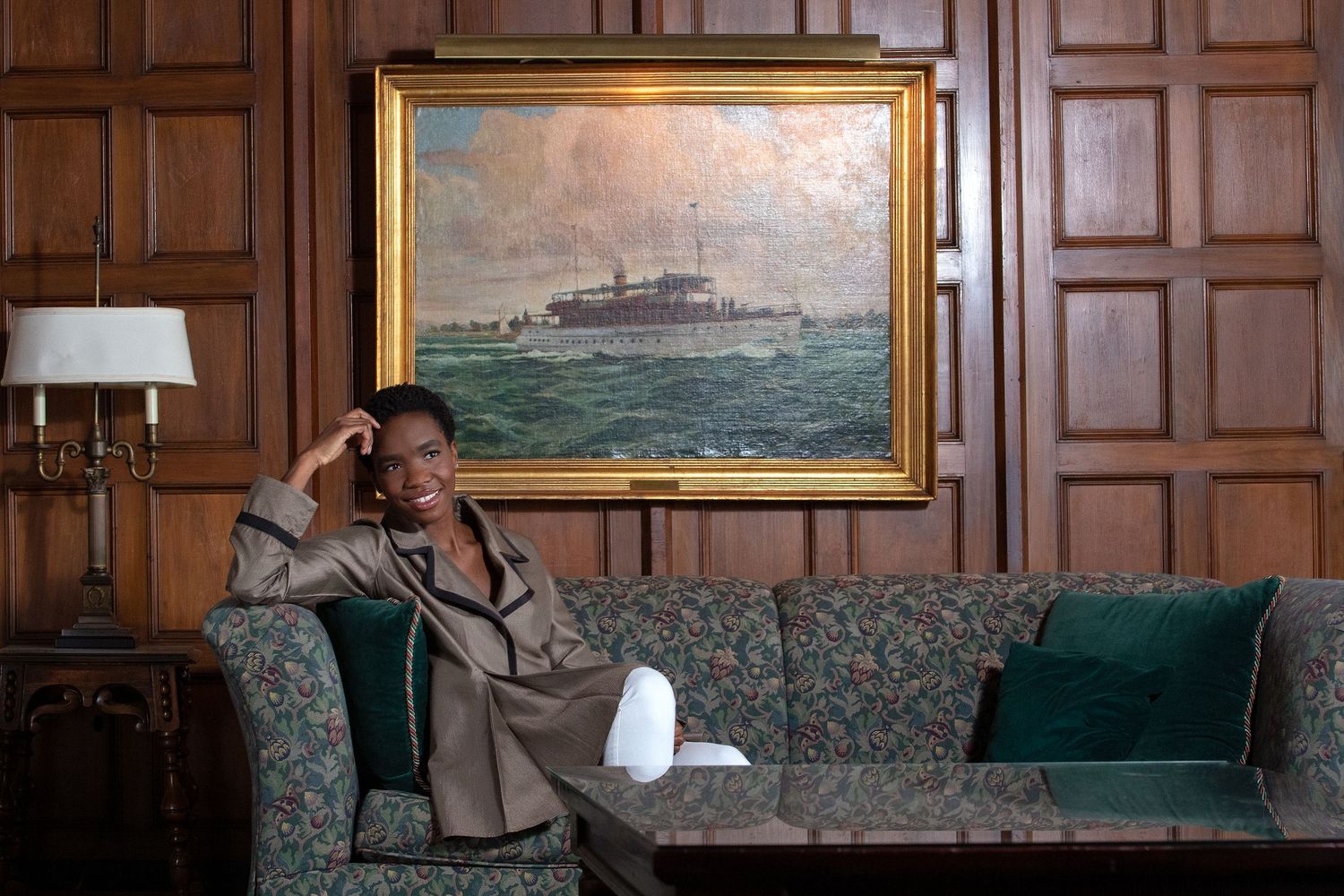 Wood-paneled room with nautical paintings and traditional furniture.