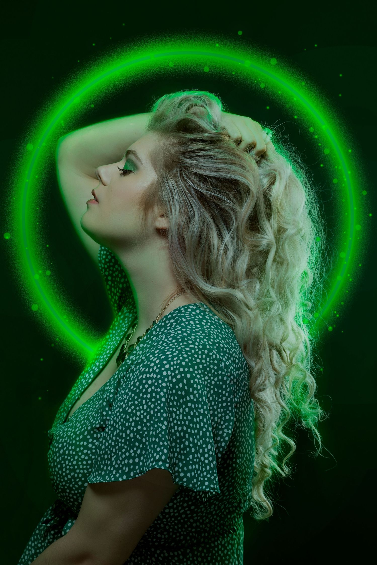 Fashion portraits with glowing green halo effect and polka dot dress against dark background.