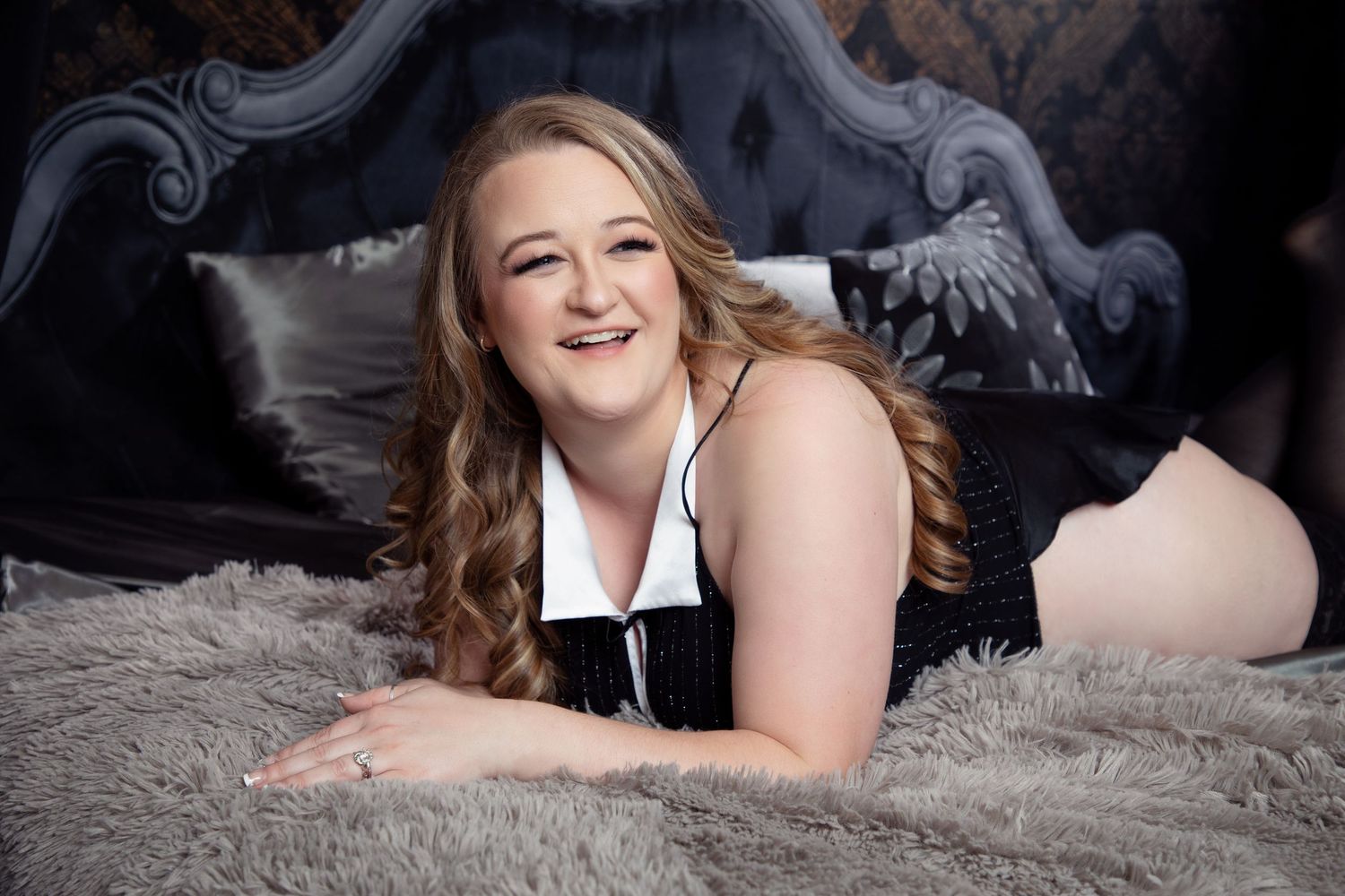 Intimate boudoir portrait session on grey fur with romantic lighting.